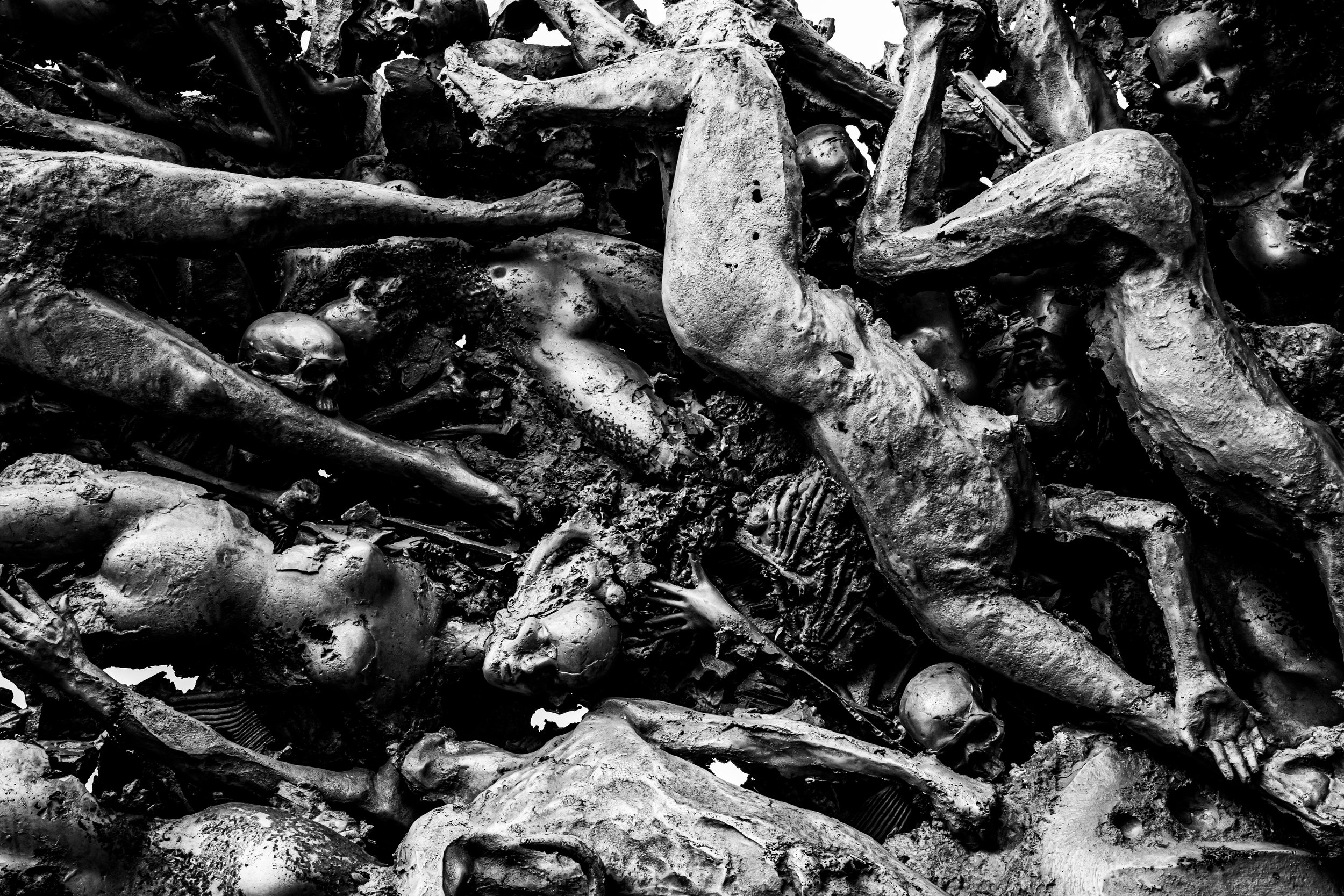 A pile of human skeletons and bones in a dark, chaotic arrangement.