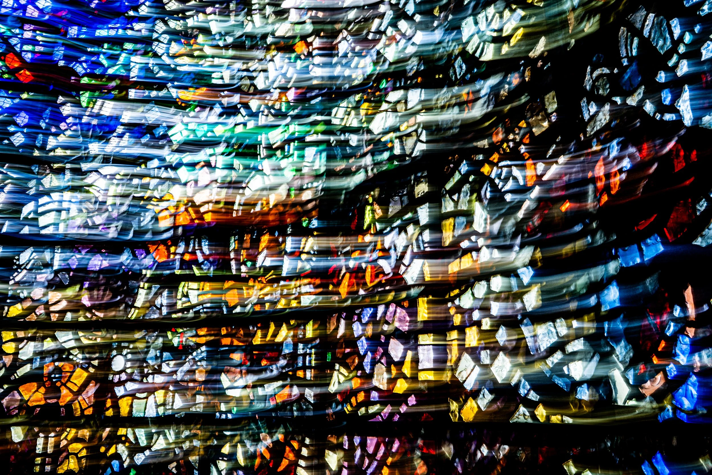 A blurred, abstract colorful display of lights resembling festive decorations or a light installation.