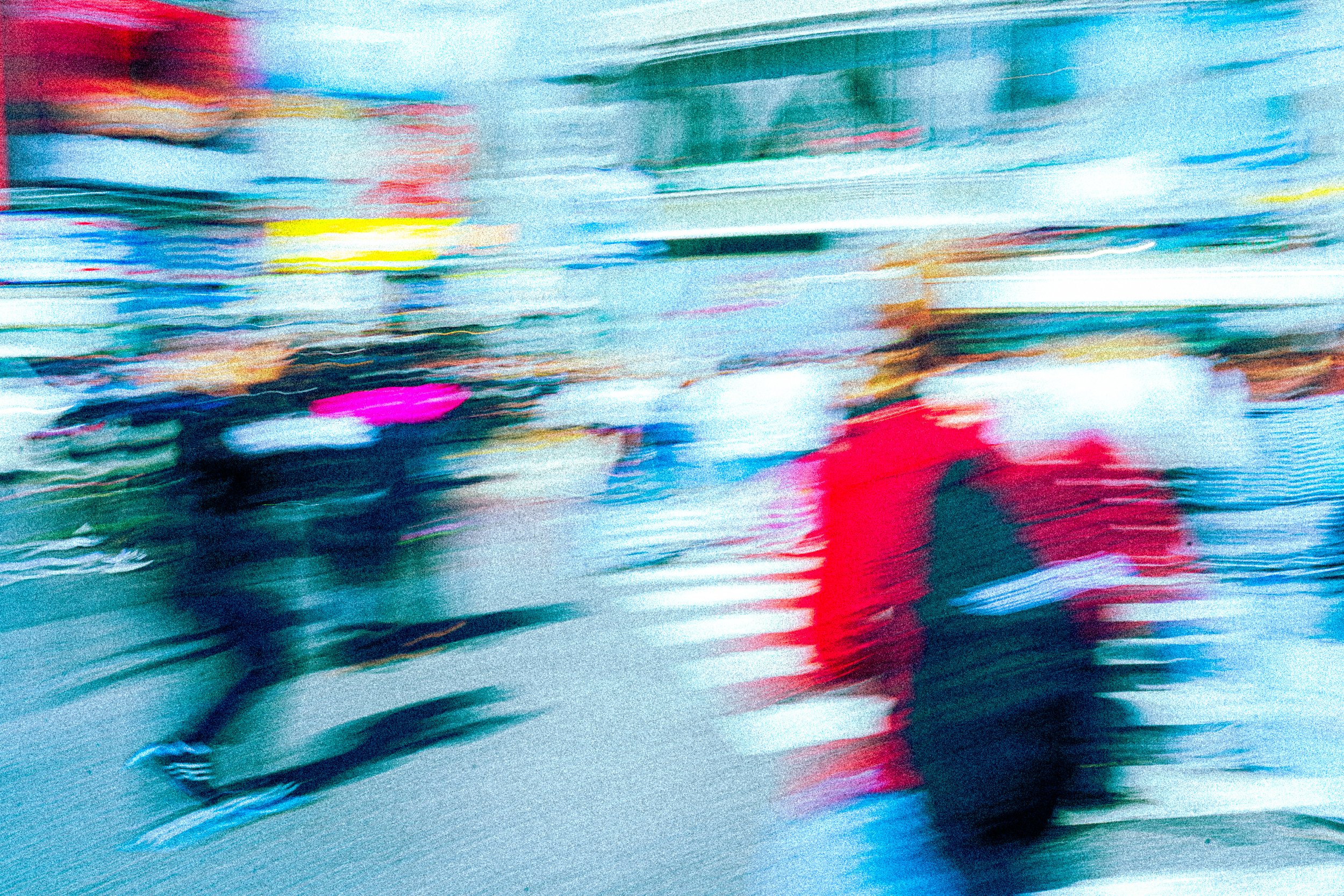 Abstract image with colorful blurred streaks and smudges in shades of blue, red, pink, yellow, and white.