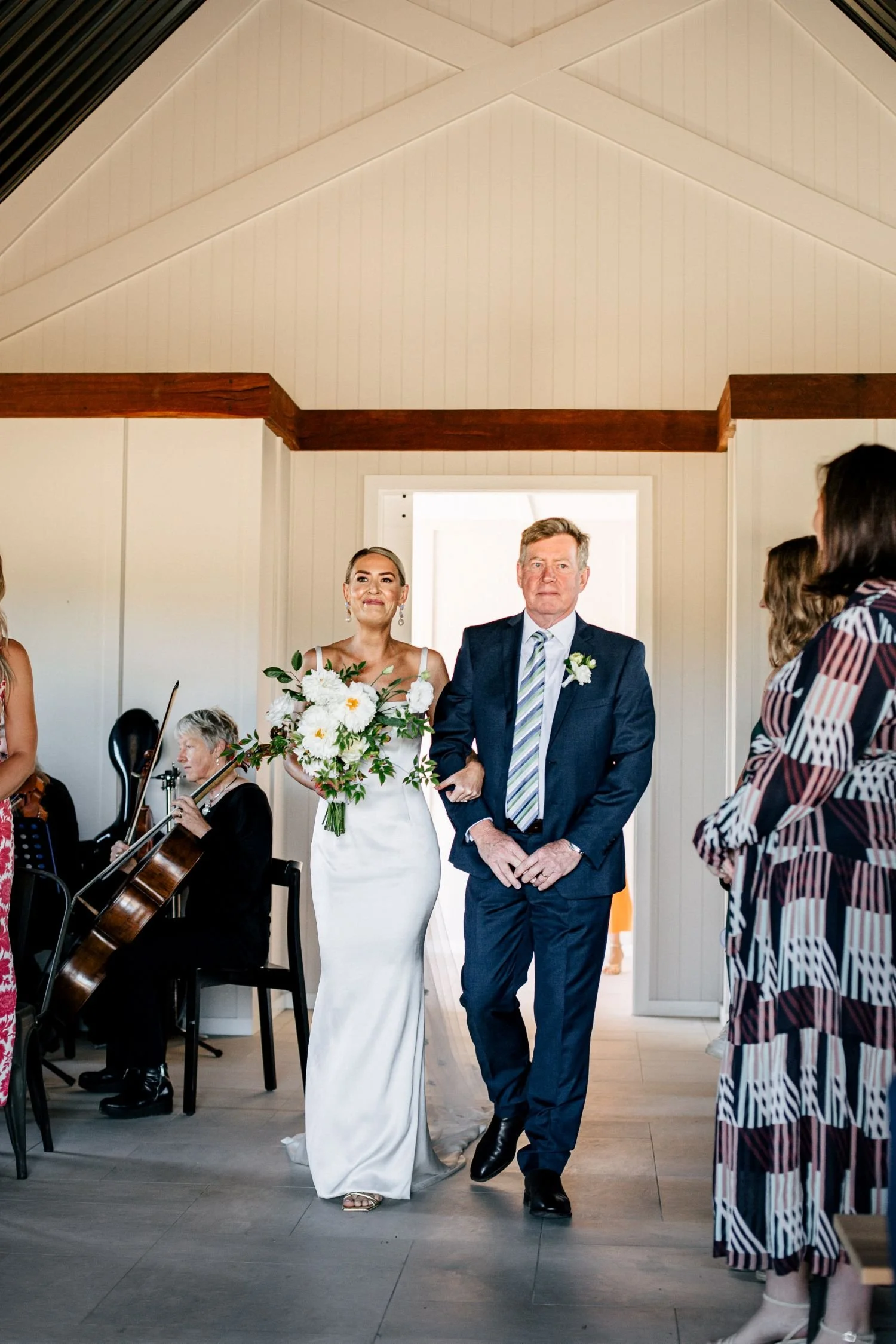 A bride and her father walking down the aisle to a string quartet for wedding ceremony