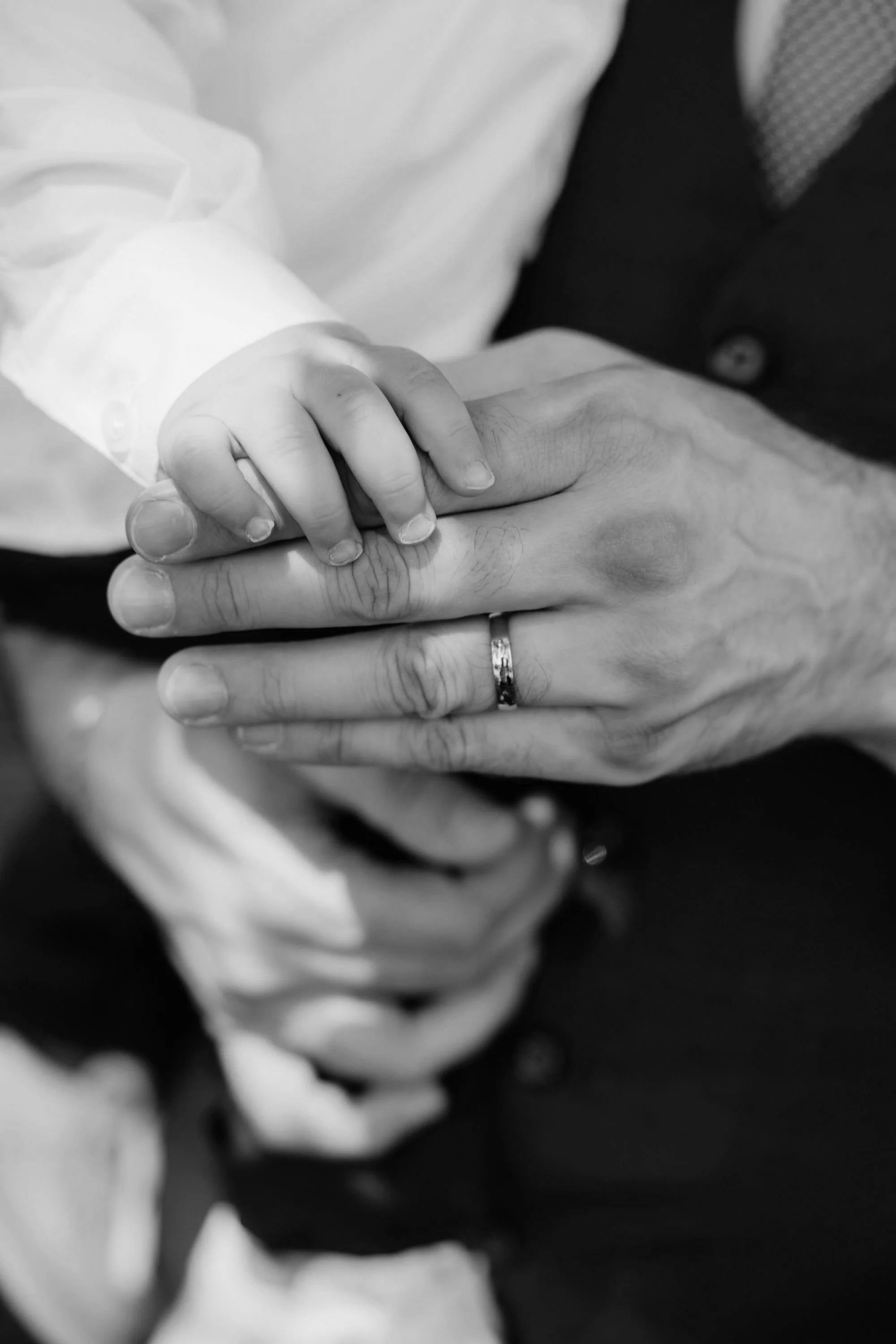 A grandfather holding his grandchild's hand at his birthday celebration