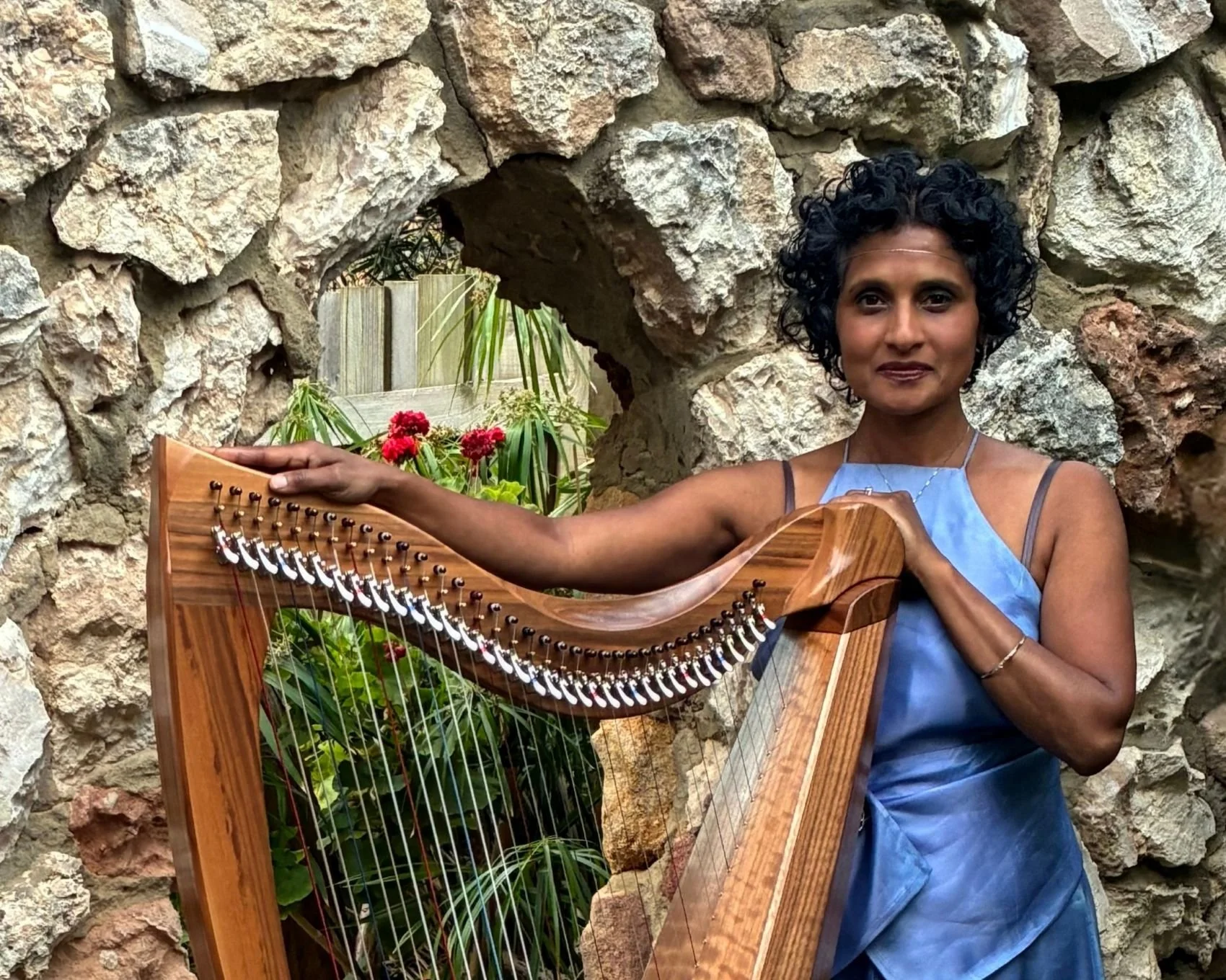 Denmark harpist hamara de Tissera standing with her harp