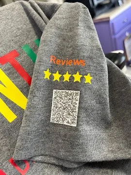 Gray shirt with 'A Google Reviews' and five yellow stars, and a QR code on the sleeve.