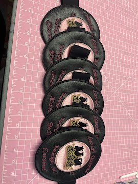 Six black motorcycle armbands embroidered with a gold crown, and black embroidered queens inside the crown appliqued with a rose gold satin cloth.
