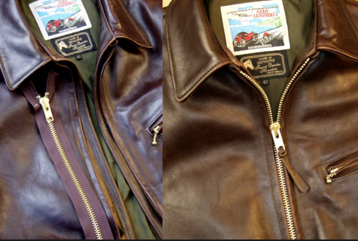Close-up of two leather jackets, side by side, with gold zippers and labels inside the collar area.