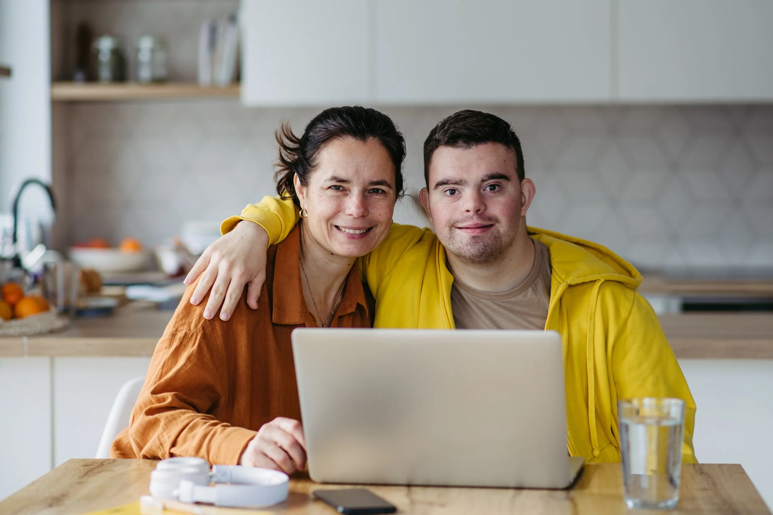 Woman and man sitting at a table smiling at the camera.