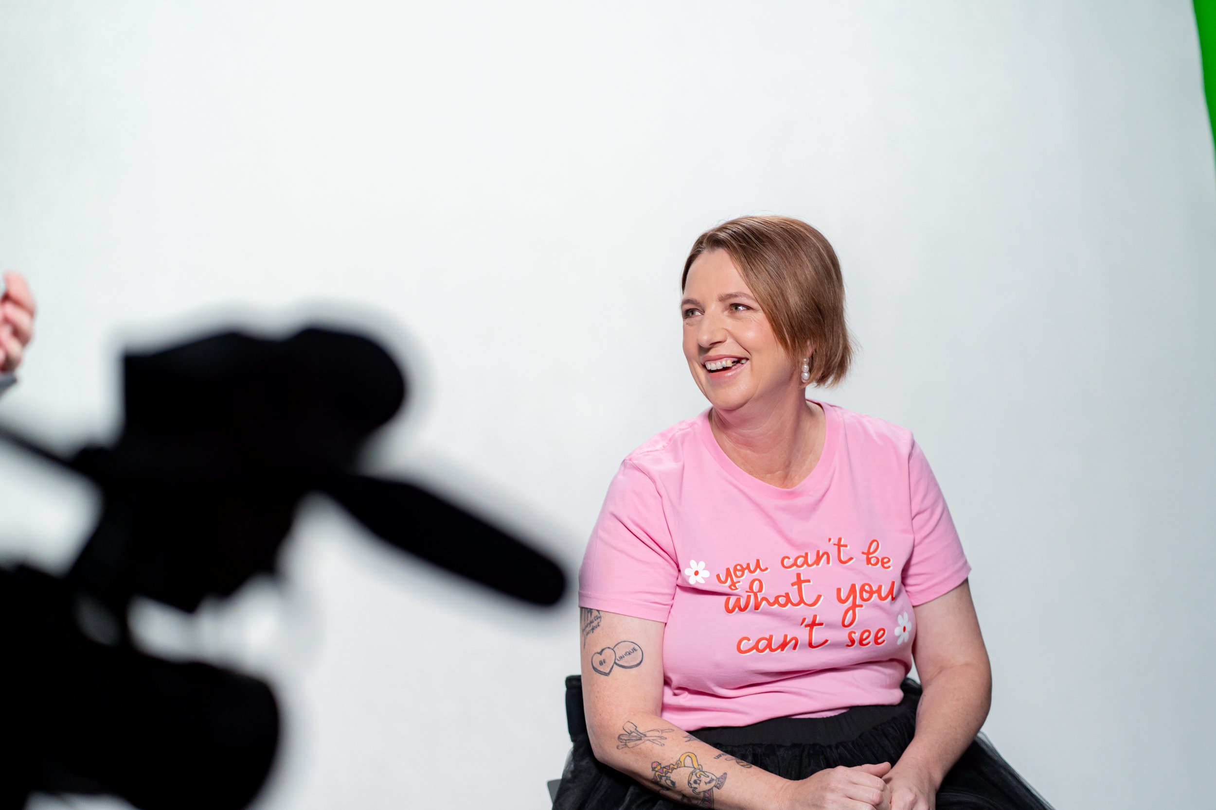 A woman in a pink shirt smiling 