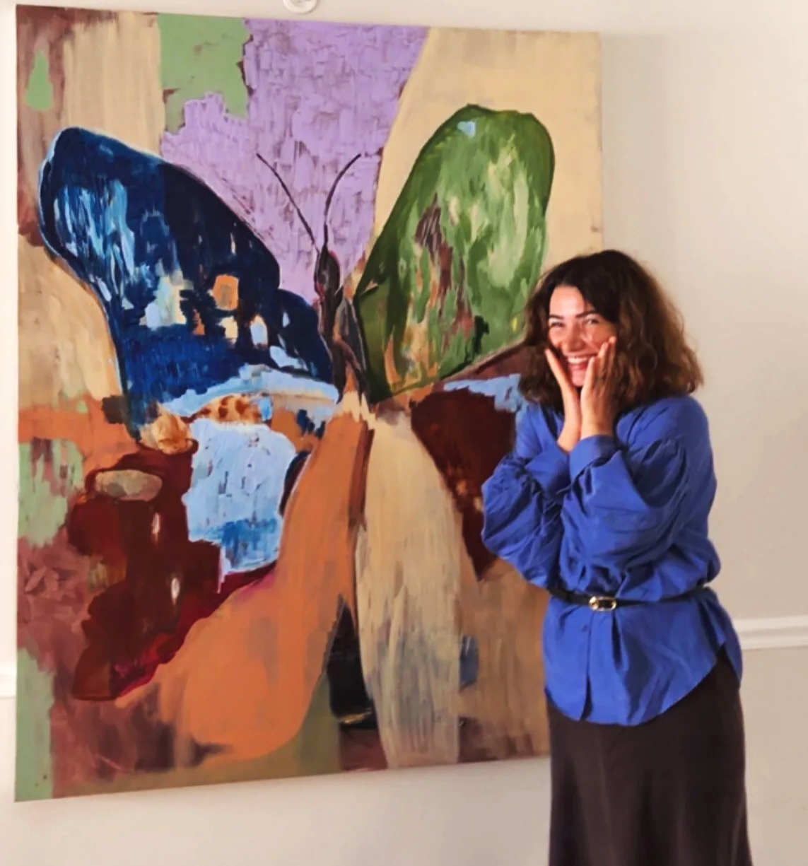 Artist Sopiko Grigolashvili standing beside her original artwork, Mother of Butterflies.