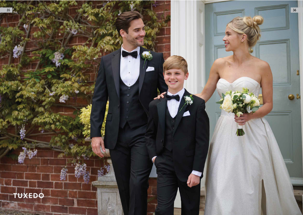 A bride and groom with a young boy at wedding outside a house with blue door, brick wall, and flowering vine.