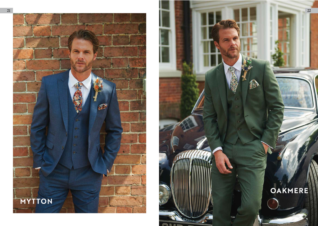 Two men wearing colorful suits and floral ties, standing outdoors in front of a brick wall and a vintage car respectively.