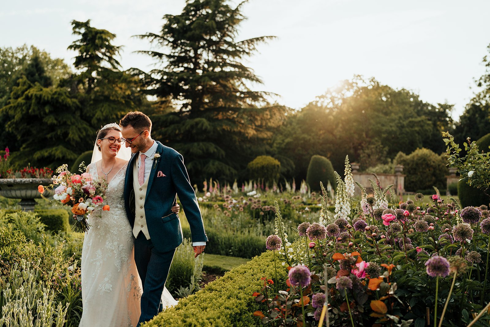 The happy couple enjoying the sunlit garden in full bloom @NathanWalkerPhotography