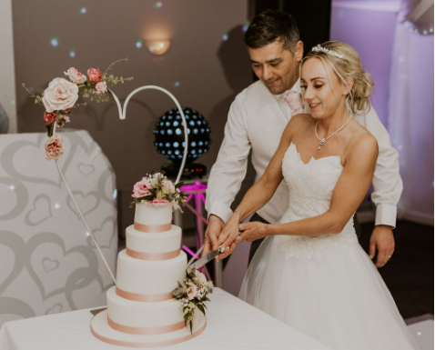 The bride and groom are cutting the cake.