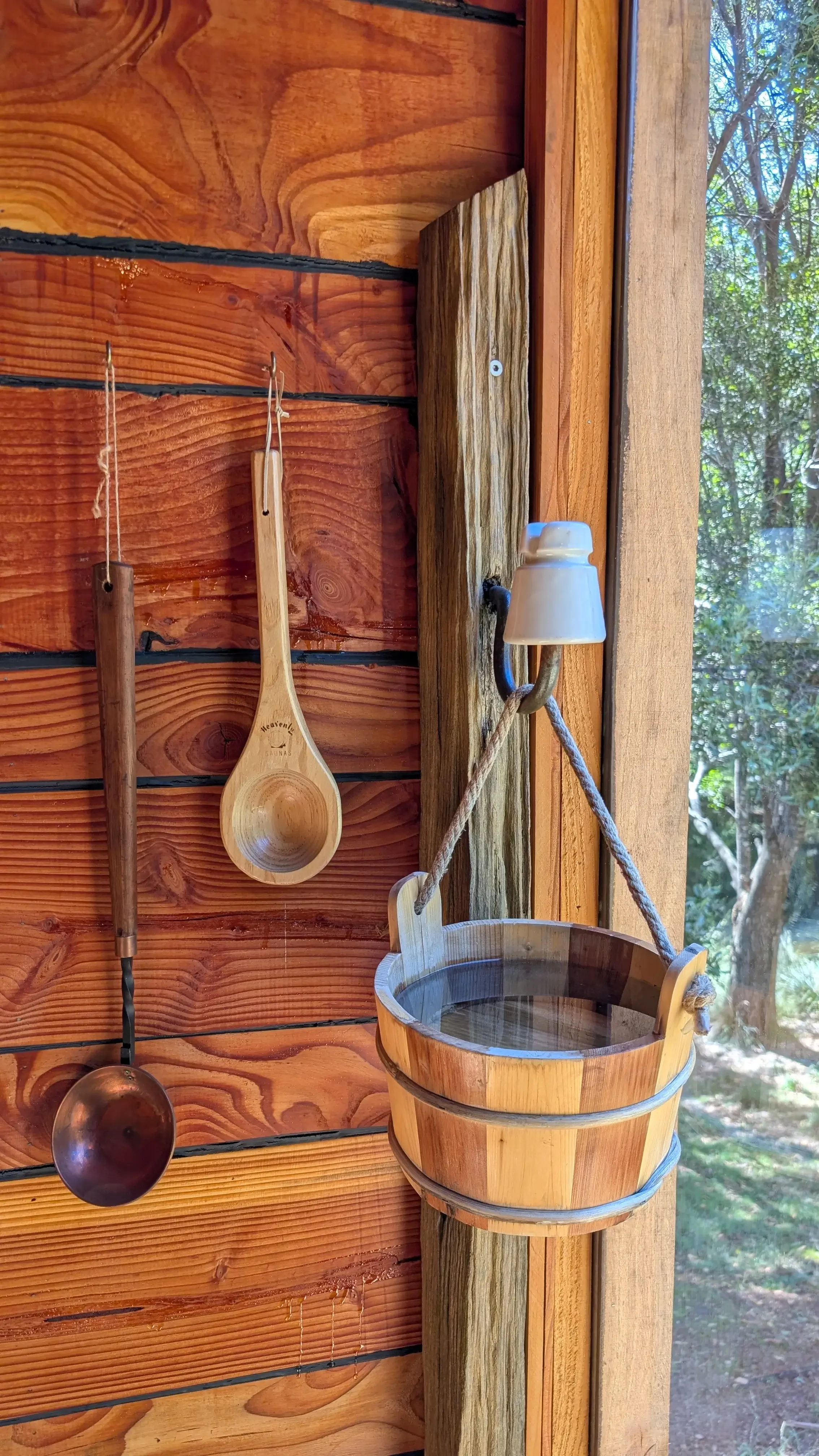 Rustic sauna bucket and ladle inside the wood-fired, private sauna and cold plunge near Derby, Tasmania.