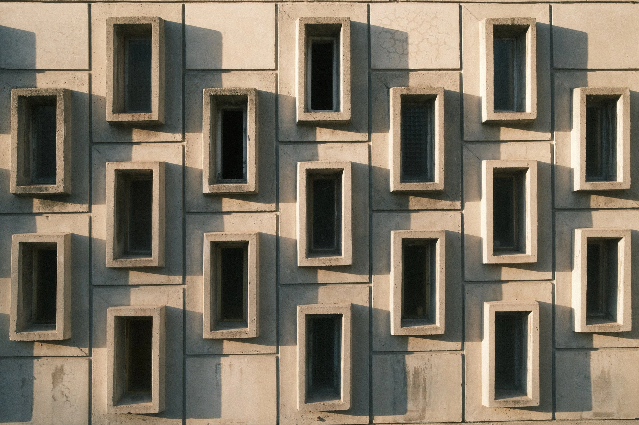 Geometric study of a concrete façade with repetitive window frames. Modern minimalist architecture by Urban Chrome.