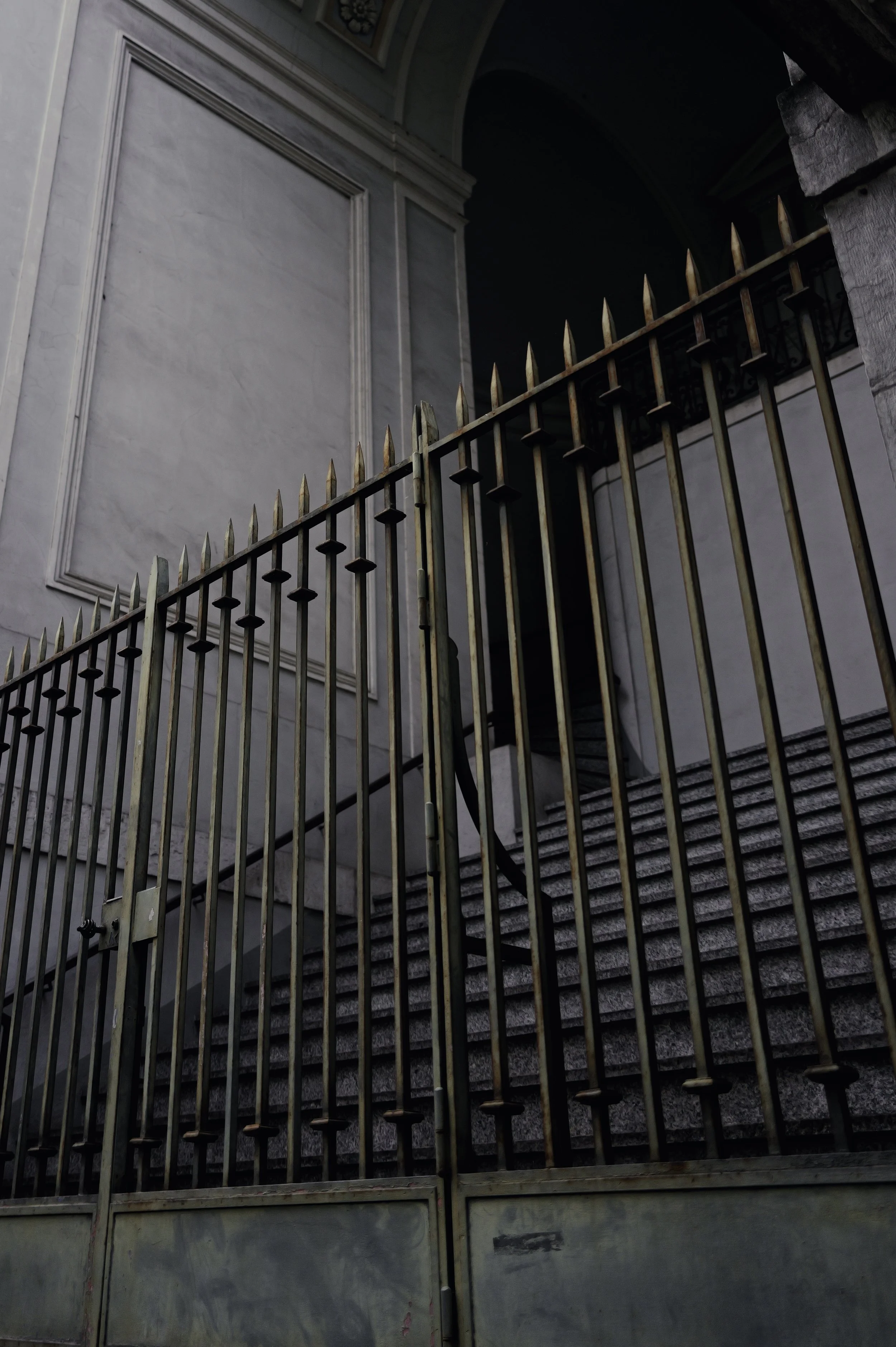 Elegant urban detail of a golden metal gate and stone steps. Intersection of classical architecture and modern urban vision.