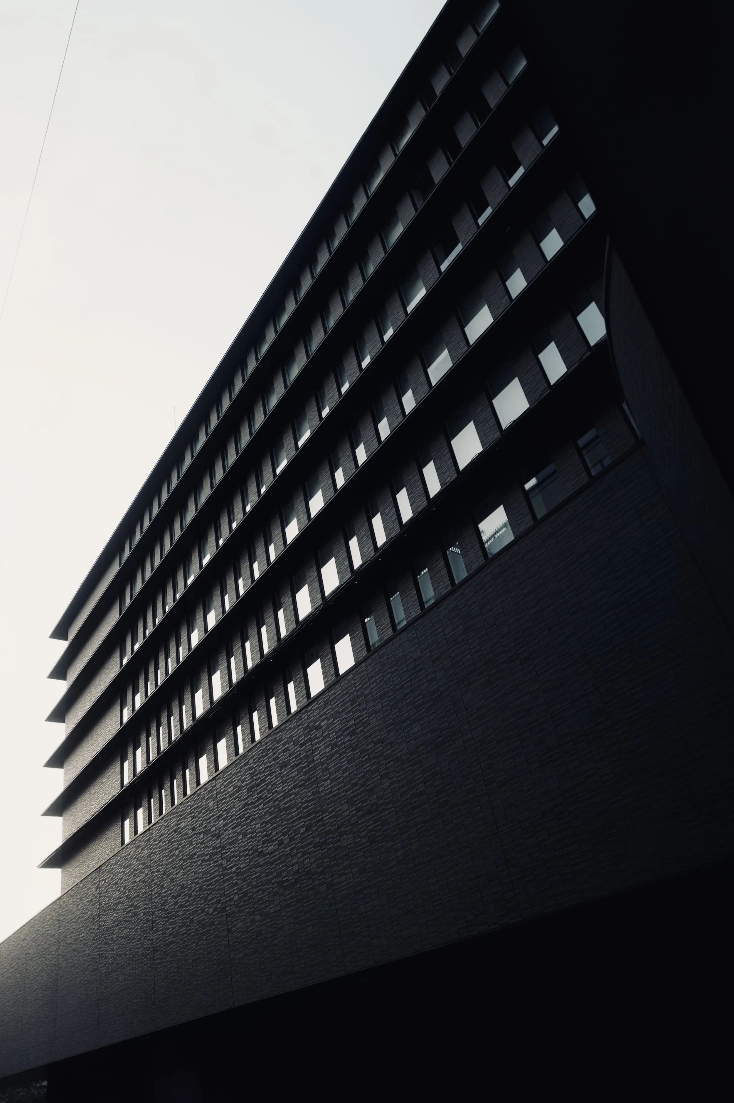 Low angle view of Kyoto Century Hotel modern curved dark facade - Minimalist urban architectural fine art photography
