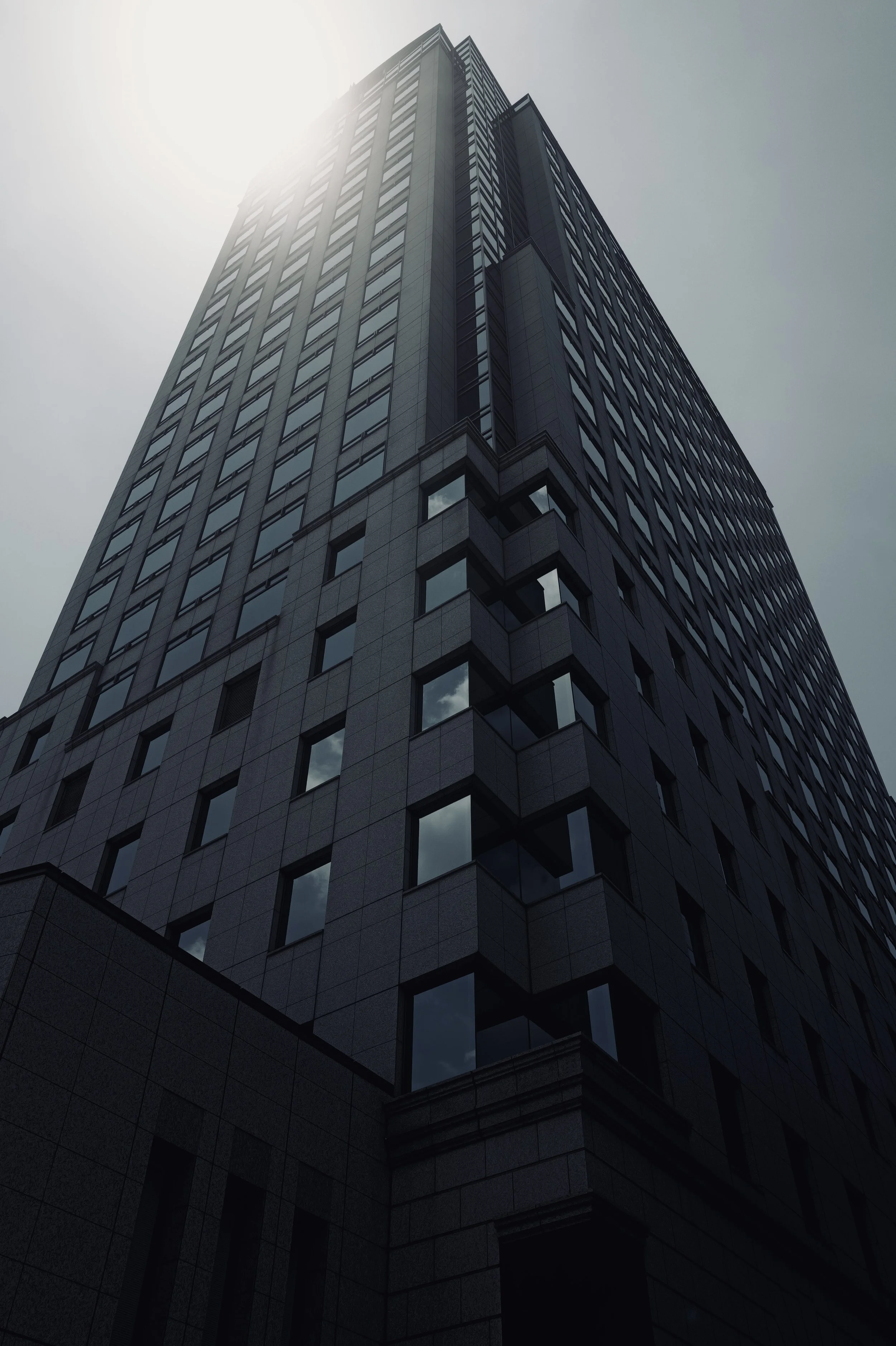 Low angle view of a modern skyscraper in Osaka with glass and dark ribbed facade - Japanese architectural fine art photography
