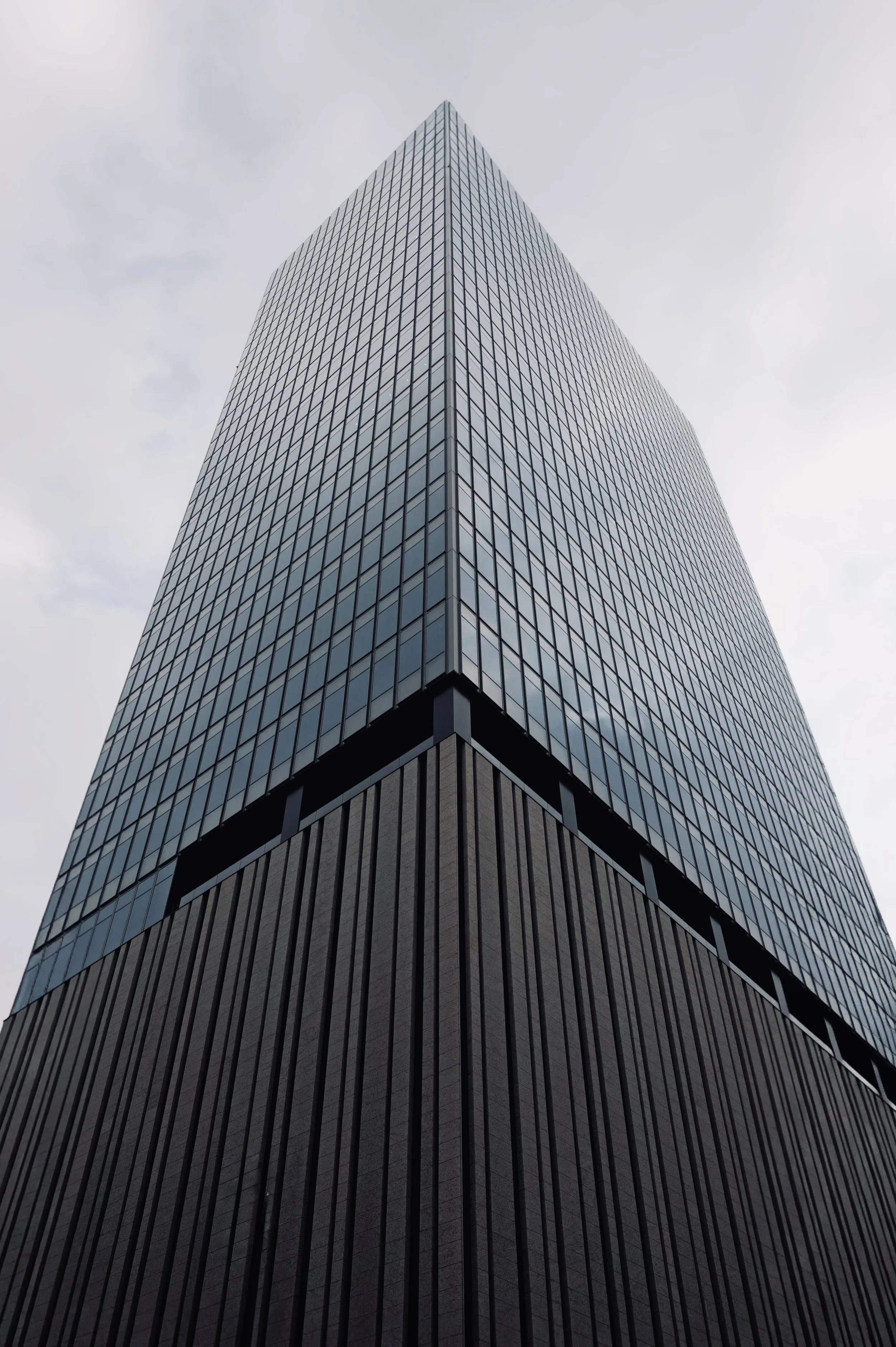 Low angle view of a modern skyscraper in Osaka with glass and dark ribbed facade - Japanese architectural fine art photography