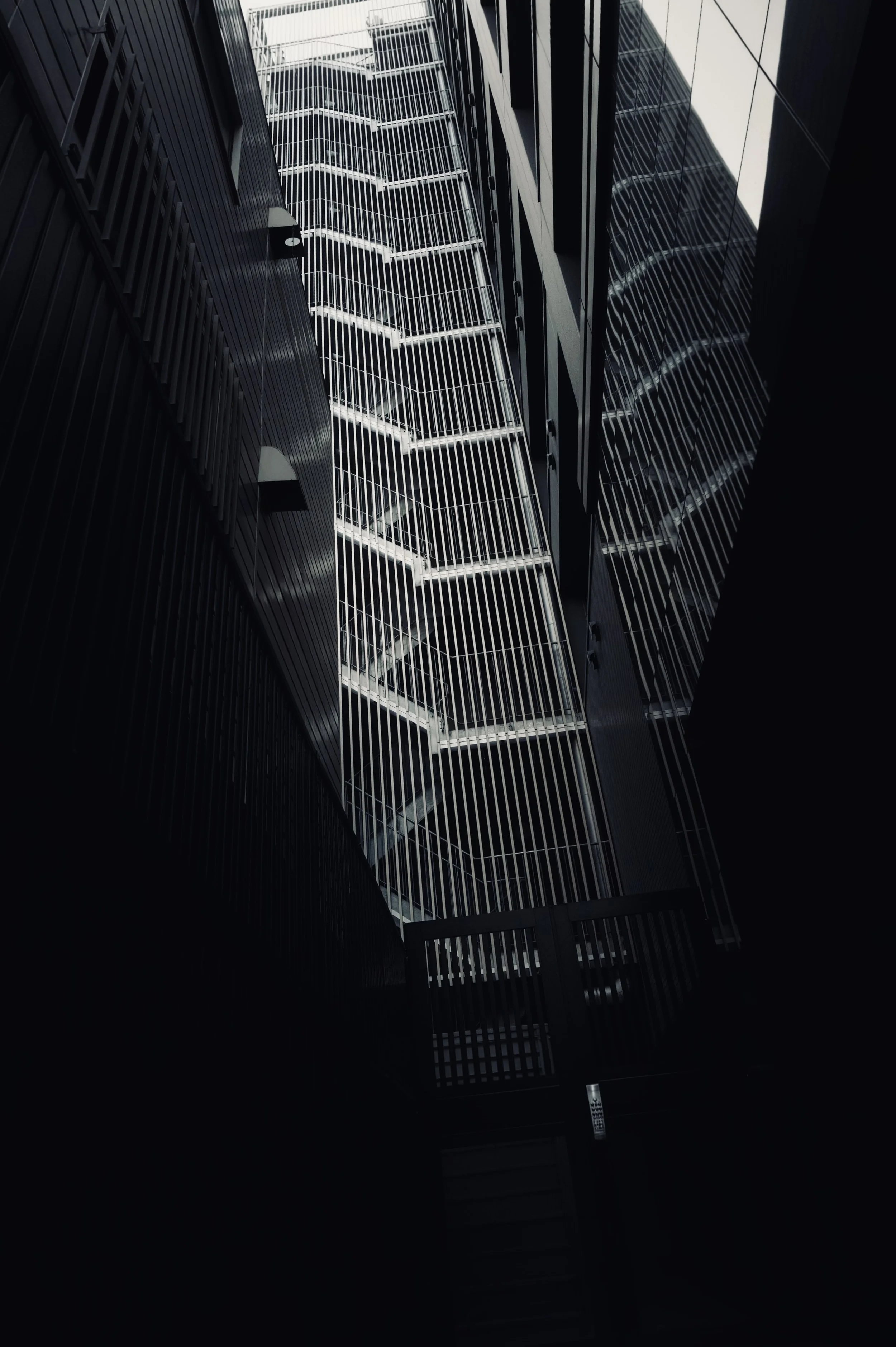 Low angle view of complex exterior metal fire escapes and dark building facades - Dark moody architectural photography