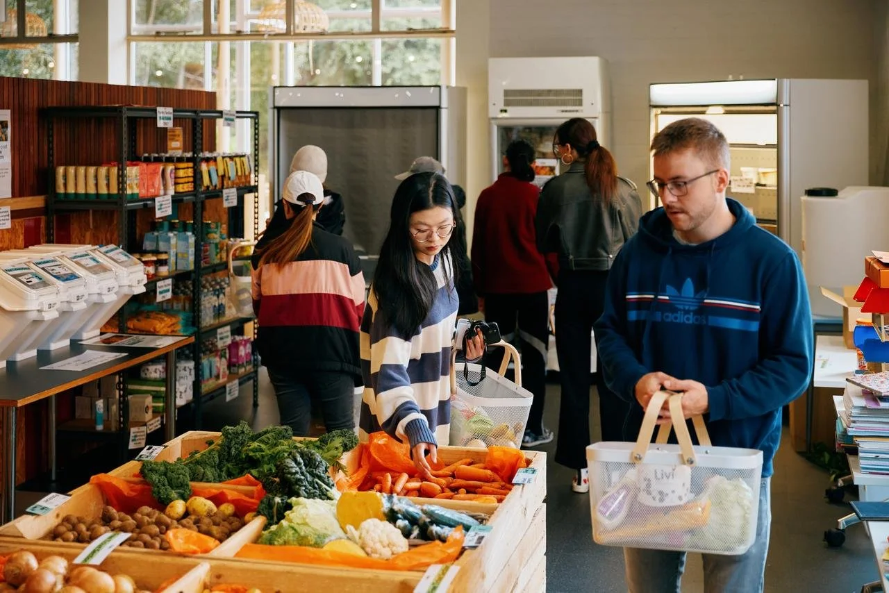 People shopping for fresh vegetables at a grocery store or farmers market.