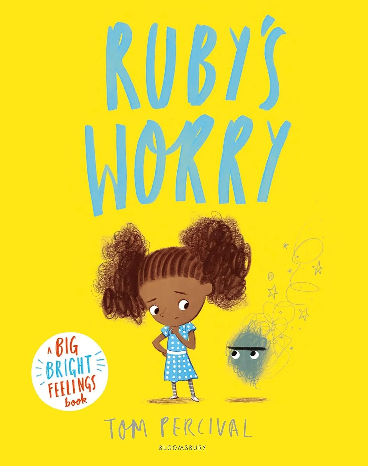 Cover of a children's book titled 'RUBY'S WORRY' by Tom Percival. The cover features a young girl with curly brown hair in pigtails, wearing a blue polka-dot dress. She appears thoughtful or worried, standing next to a small scribbled cloud with eyes and a faint outline of the girl’s worry.