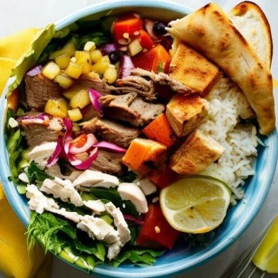 A bowl of taco salad with lettuce, shredded chicken, cheese, tomato, corn, black beans, purple onion, diced beef, tortilla chips, a lemon wedge, and a side of yellow mustard.