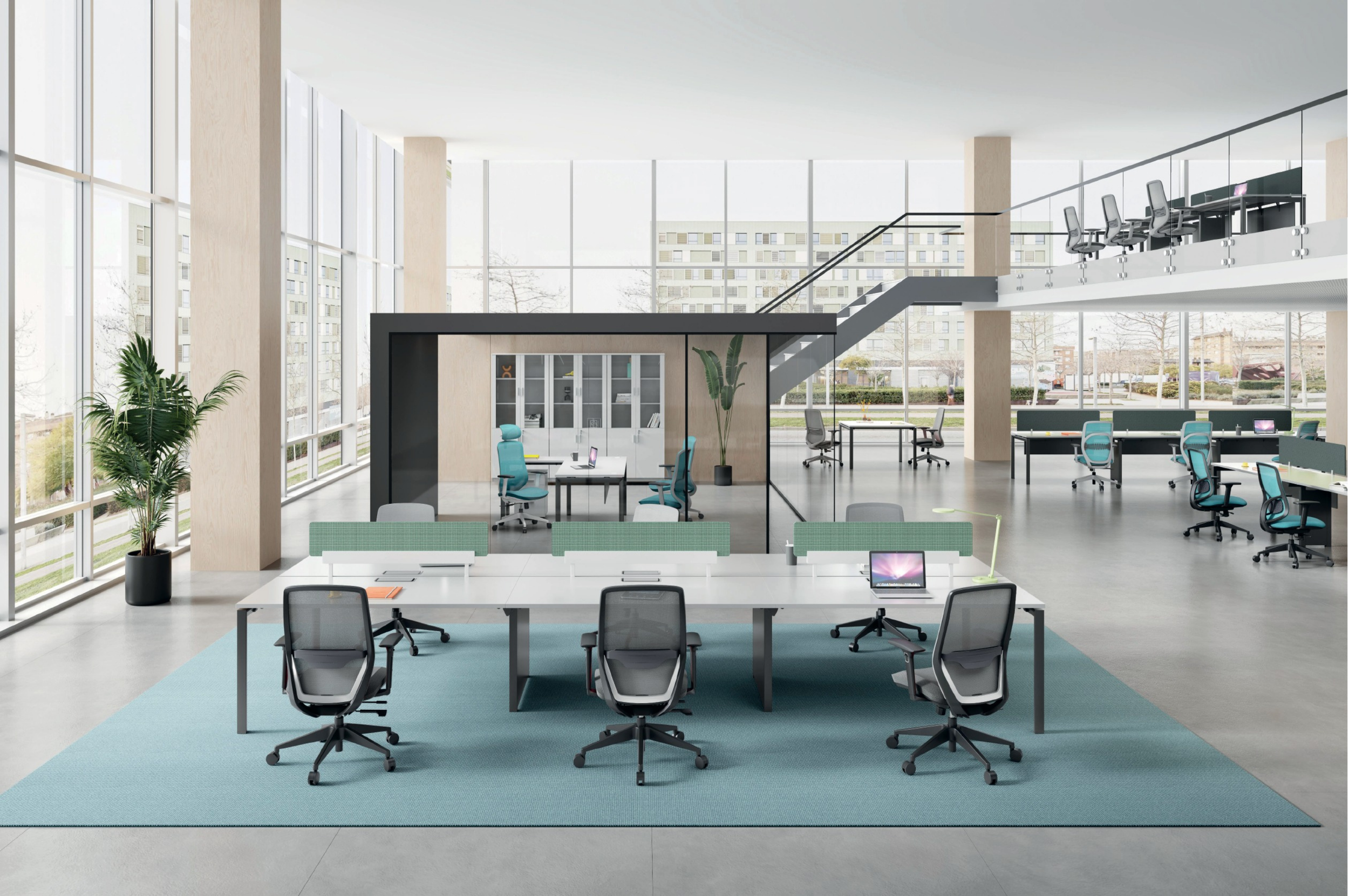 A spacious modern office with large floor-to-ceiling windows, multiple workstations with chairs and laptops, a blue area rug, potted plants, and a mezzanine level with additional work desks and chairs.