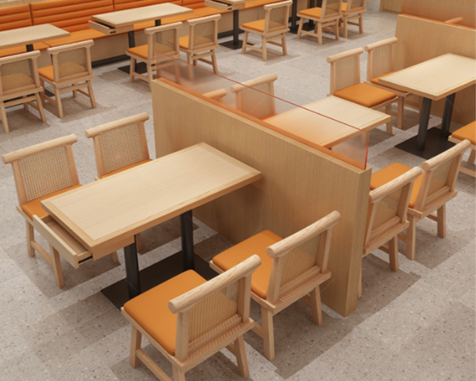 Empty restaurant dining area with light wood tables and chairs, separated by wooden dividers, with orange cushions on the seats.