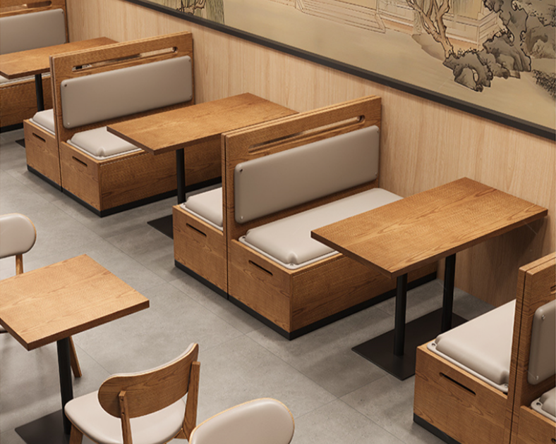Empty booth-style and individual tables with white cushioned seats in a restaurant interior with wooden accents and a decorative wall mural.