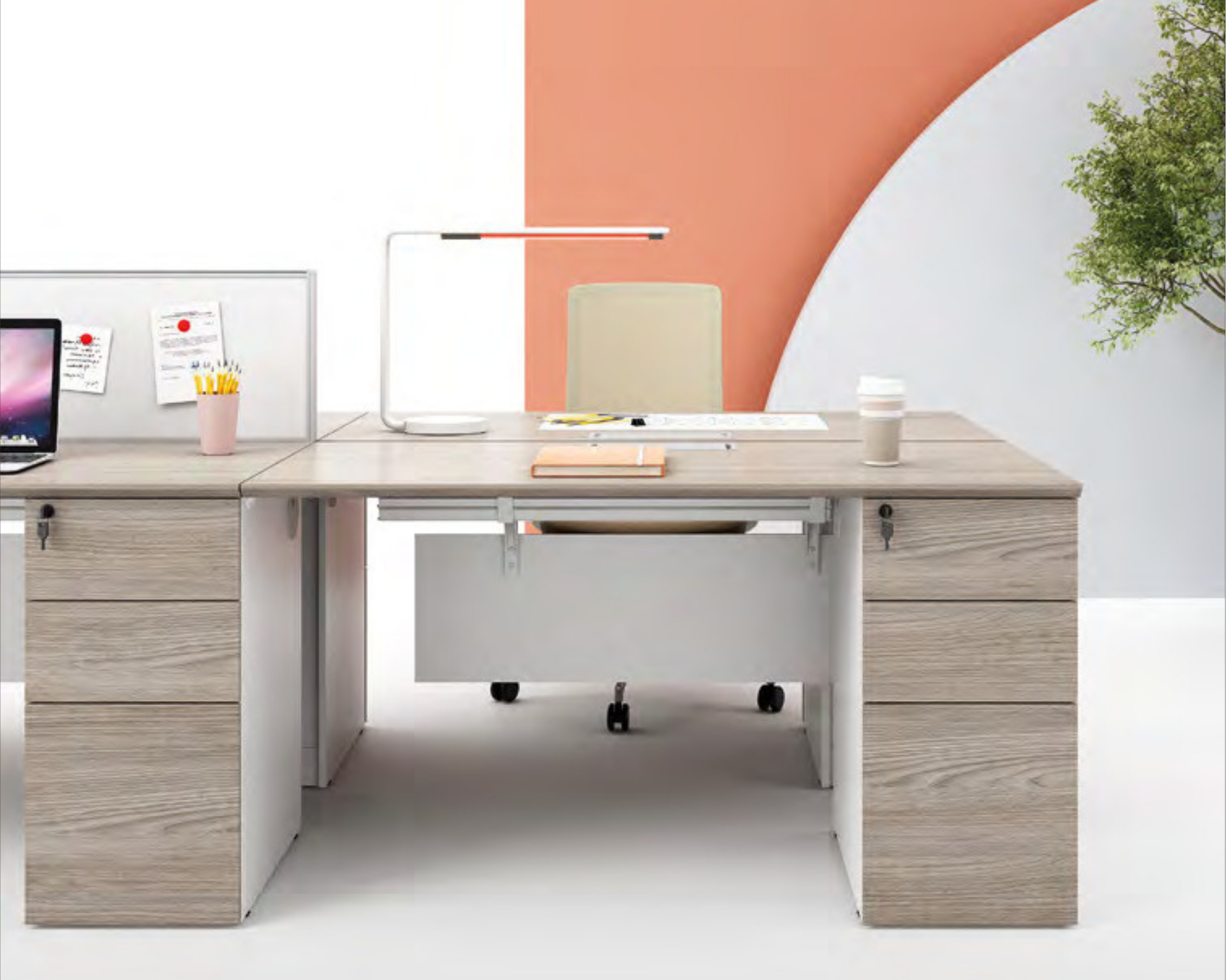 A modern office workspace with a light wood desk, a computer monitor, a pink cup with yellow pencils, a water glass, and decorative notes and plants, with a colorful curved wall in the background.