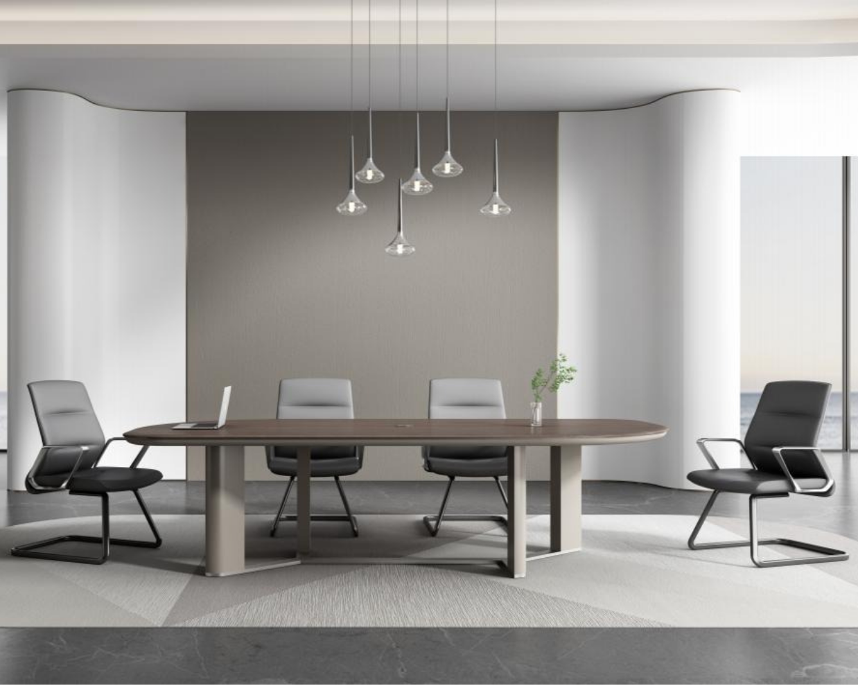 Modern office conference room with a wooden oval table, four chairs, pendant lights, a laptop, and a small plant, overlooking a body of water through large windows.