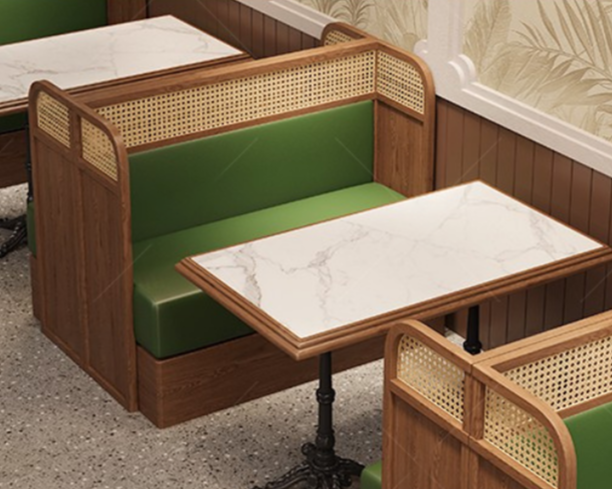Booth seating with green cushioned bench and marble-topped table in a restaurant.