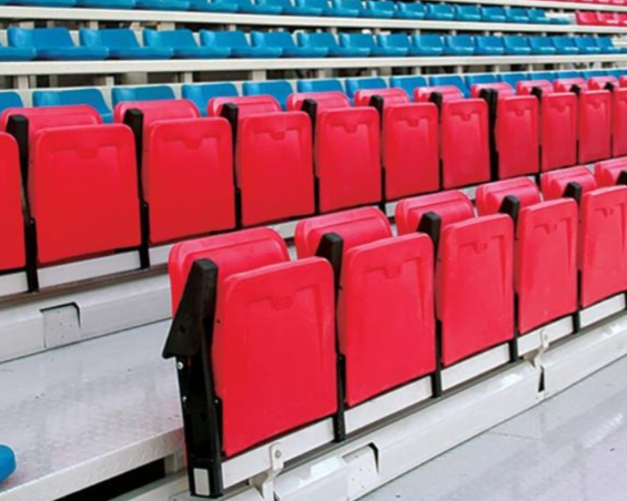 Empty red stadium seats with a higher row of blue seats in the background.