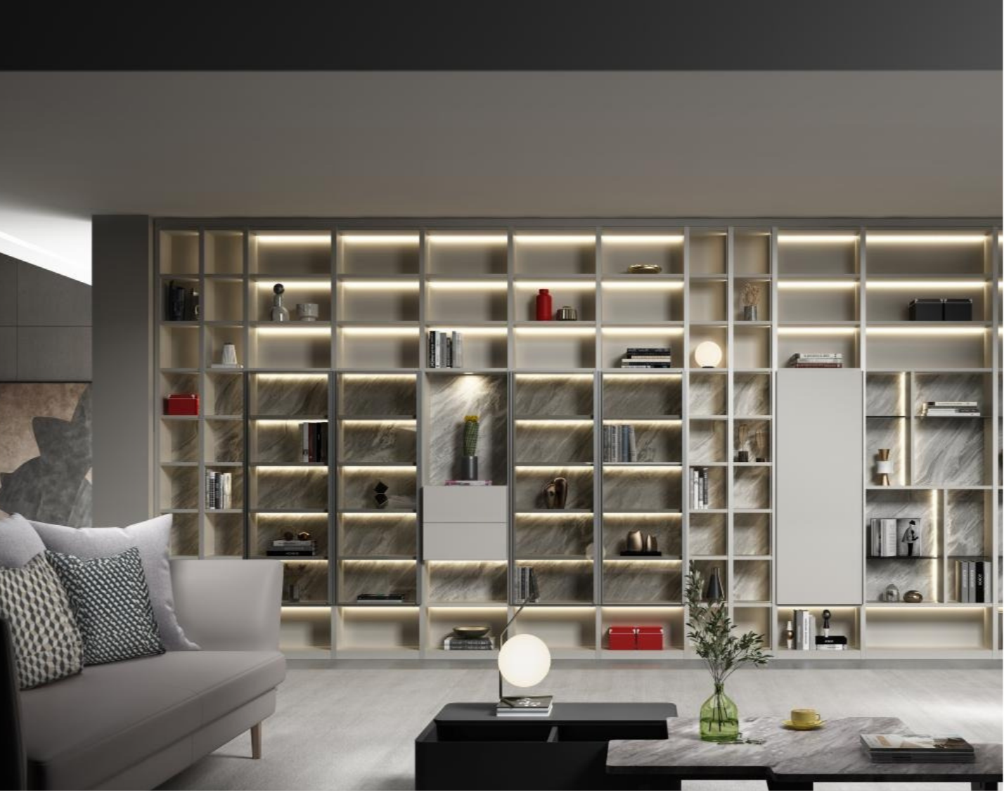Modern living room with a large wall-mounted bookshelf with built-in lighting, holding various decorative items and books, a white sofa with patterned cushions, a black coffee table with a globe lamp and a green vase, and a marble-topped side table with yellow and white decor objects.