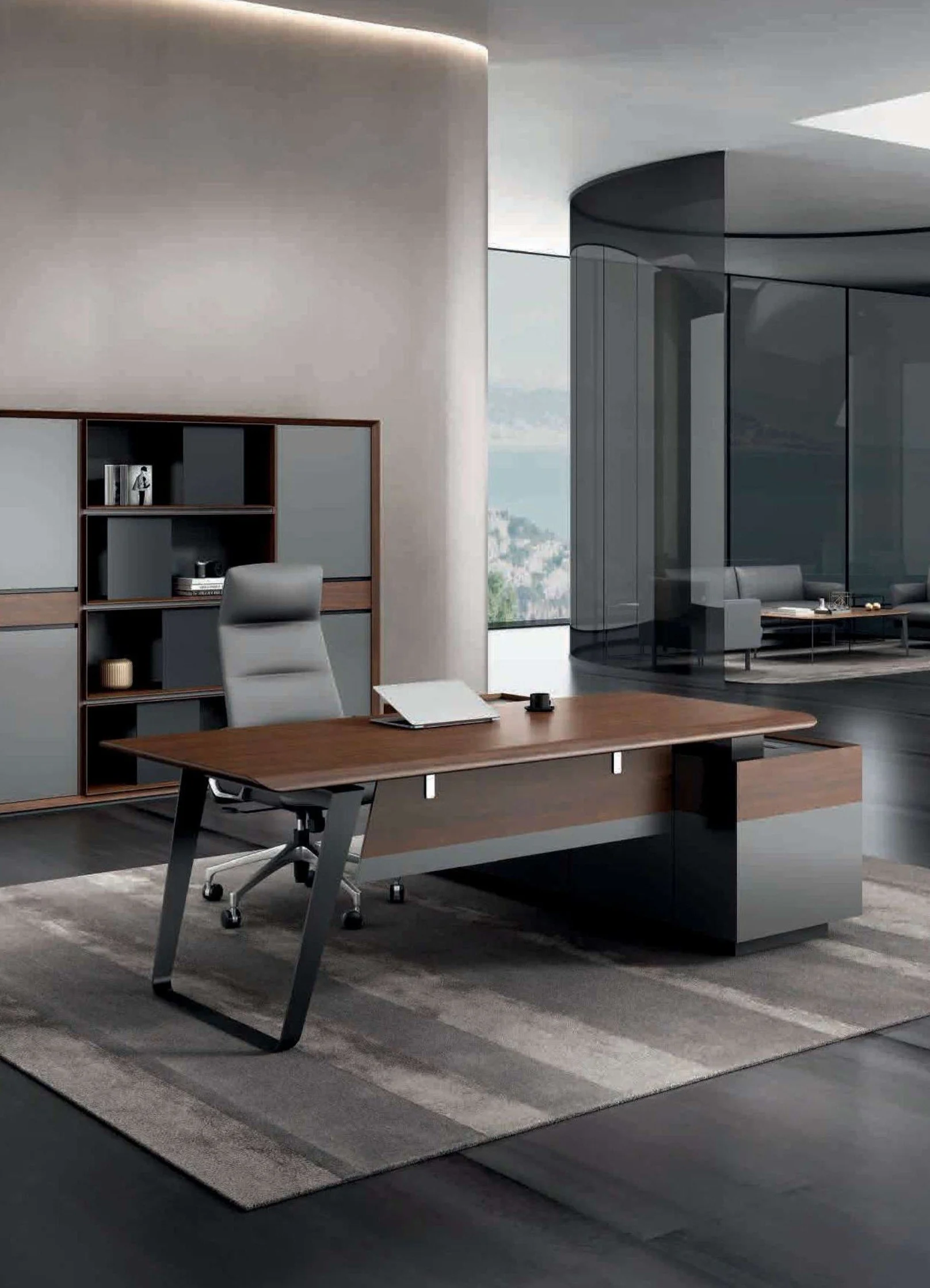 Modern office space with a large wooden desk, a gray ergonomic office chair, and a bookshelf. In the background, a curved glass wall reveals a sitting area with a sofa and a view of a cityscape.