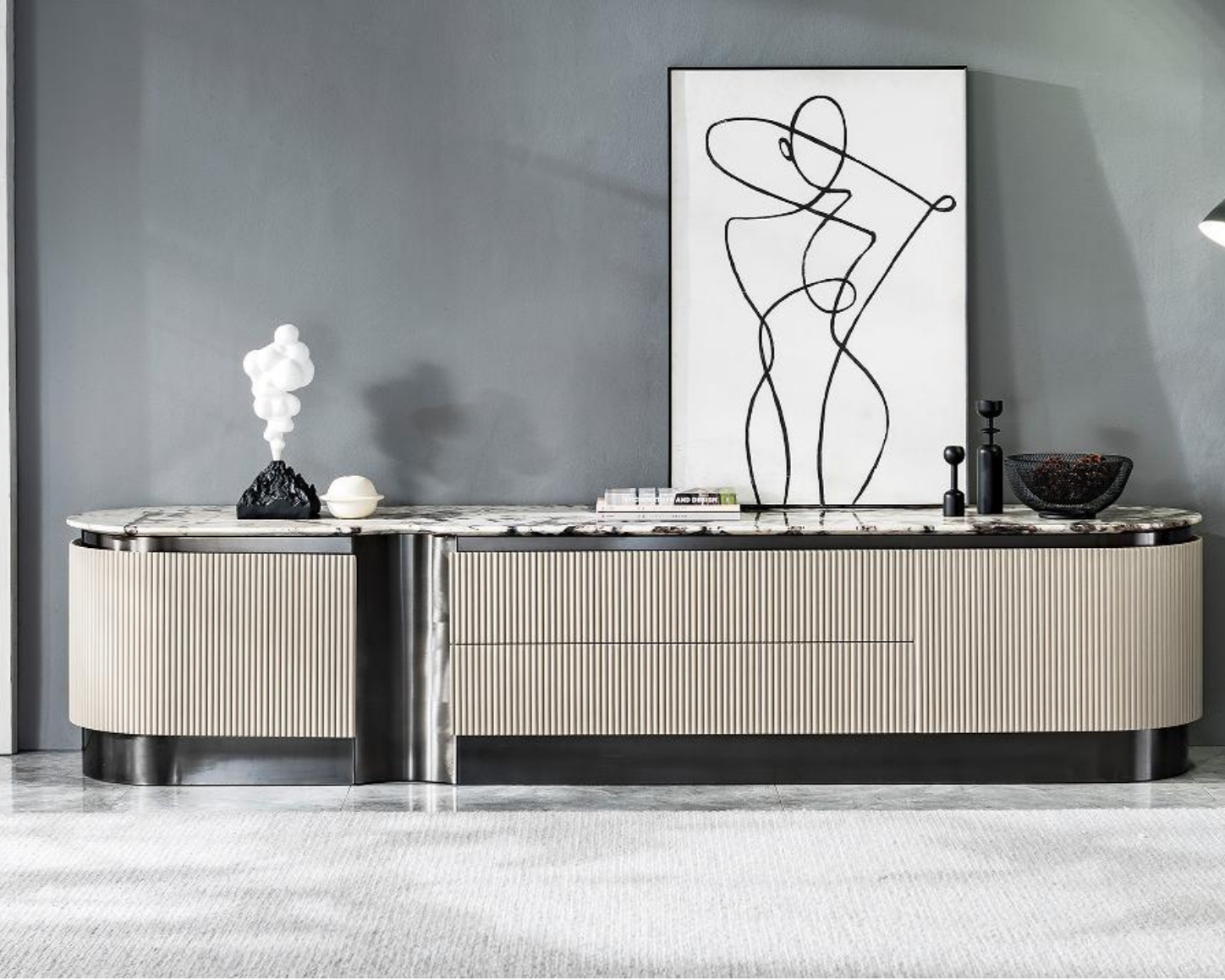 Modern sideboard against gray wall with decorative items, abstract line art painting, and a few books on top.