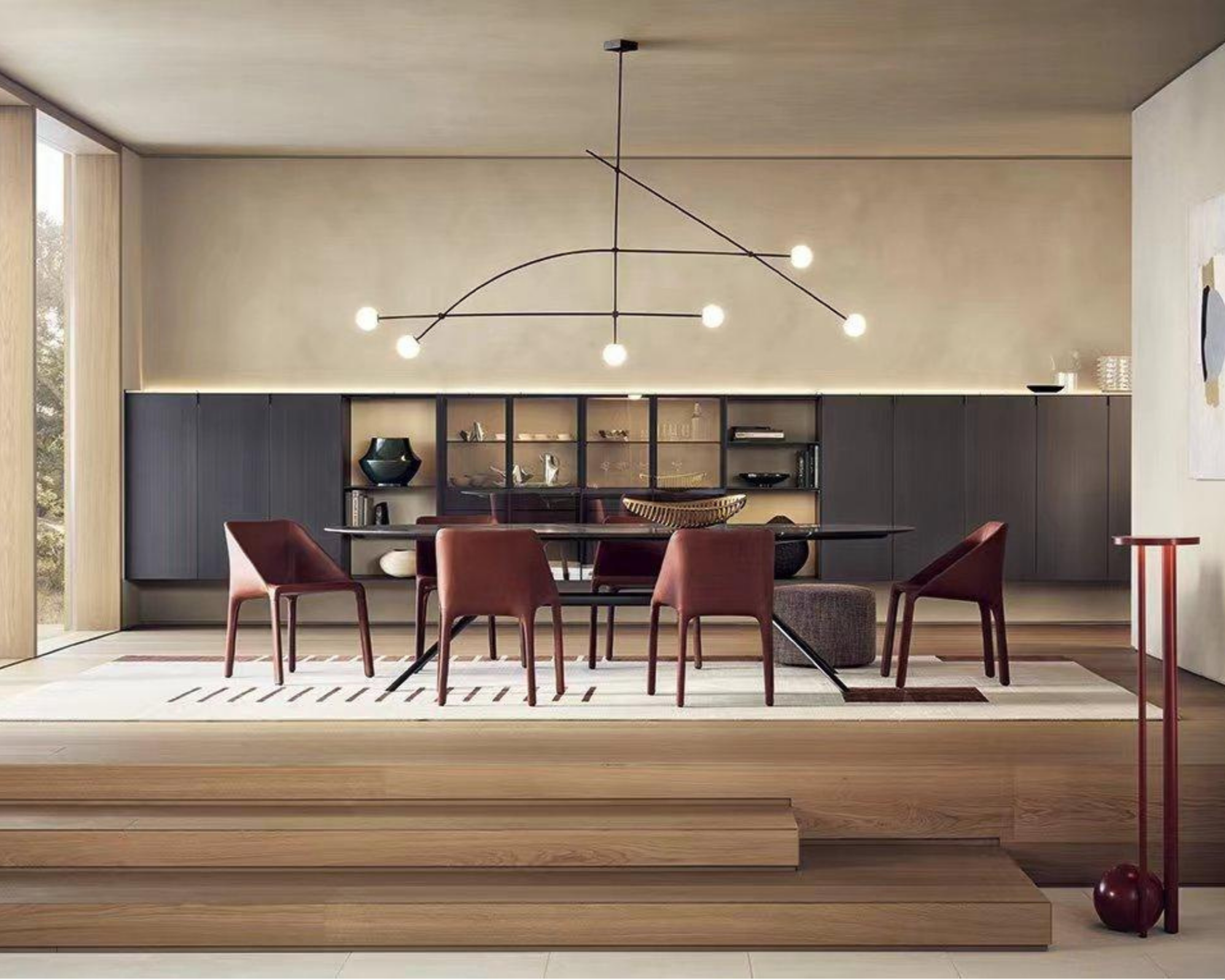 Living room with black wall cabinets, a circular black table with burgundy chairs, a modern black chandelier with multiple lights, and a light wooden platform in the foreground.
