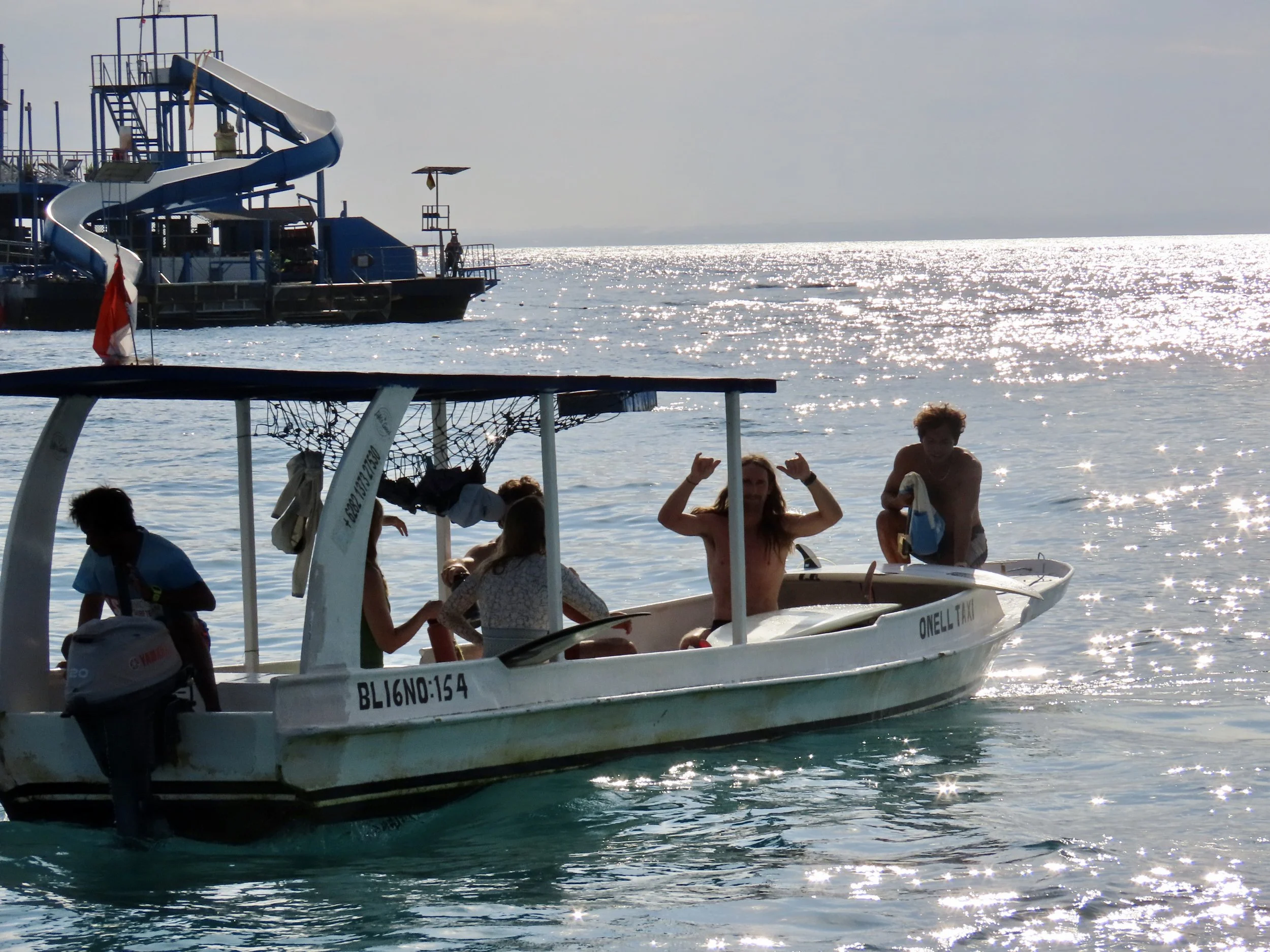 Boats and surfers off the coast of Nusa Lembongan