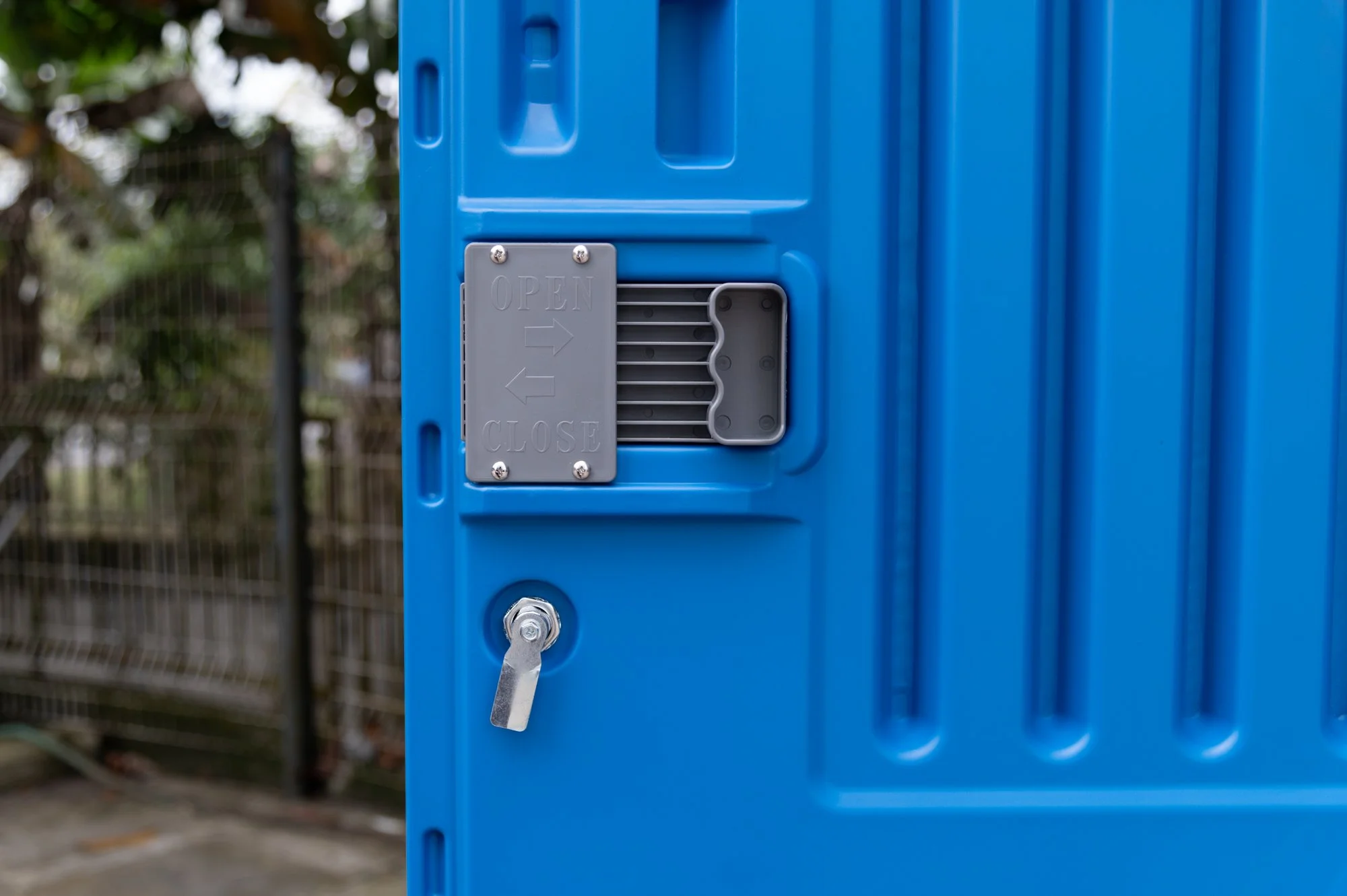 Close-up full-service portable toilet door lock and an open/close indicator sign in Brunei.