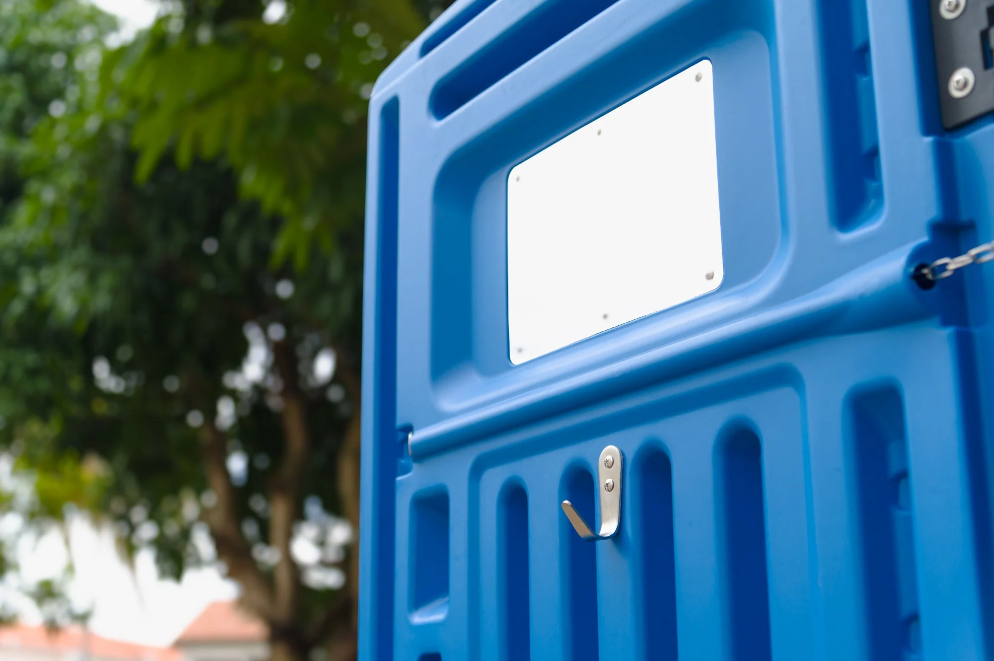 Full-service portable toilet rental with a mirror and clothes hook on the door in Brunei.