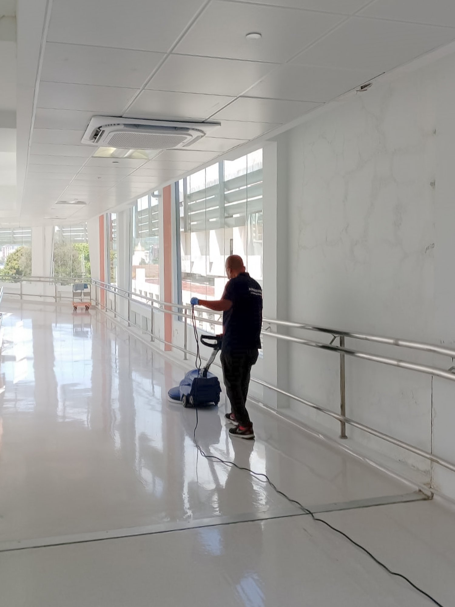 Professional floor polishing taking place in a corridor of a commercial building in Brunei.