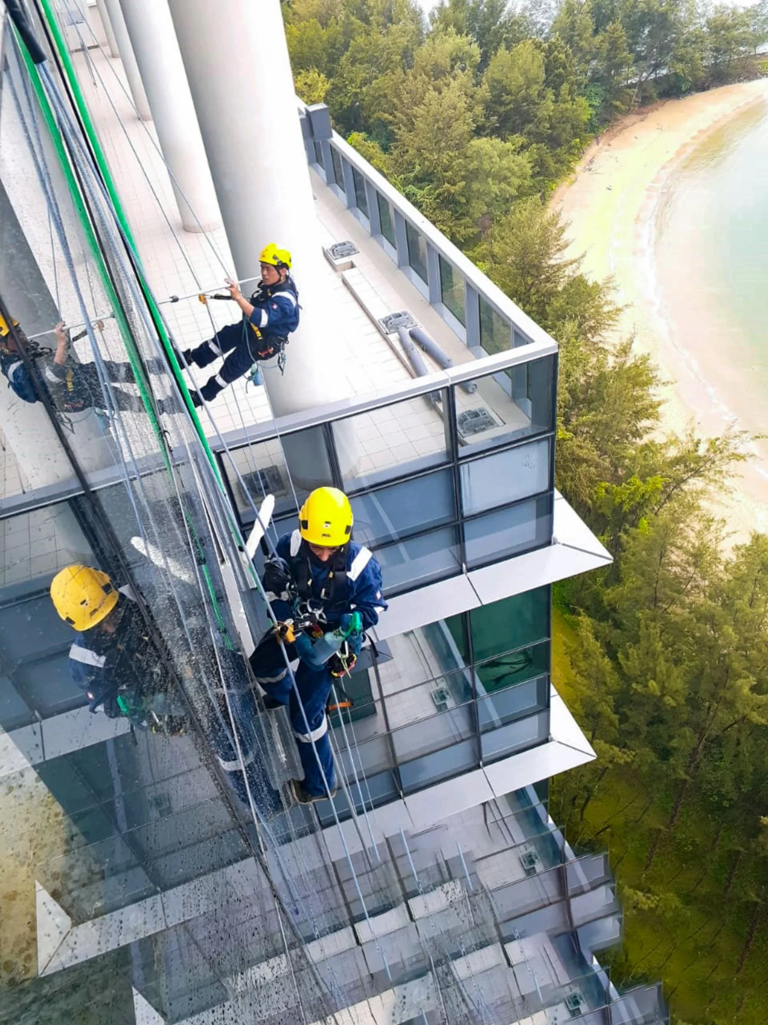 Professional window & building facade cleaning with experienced abseiling team taking place outdoors in Brunei.