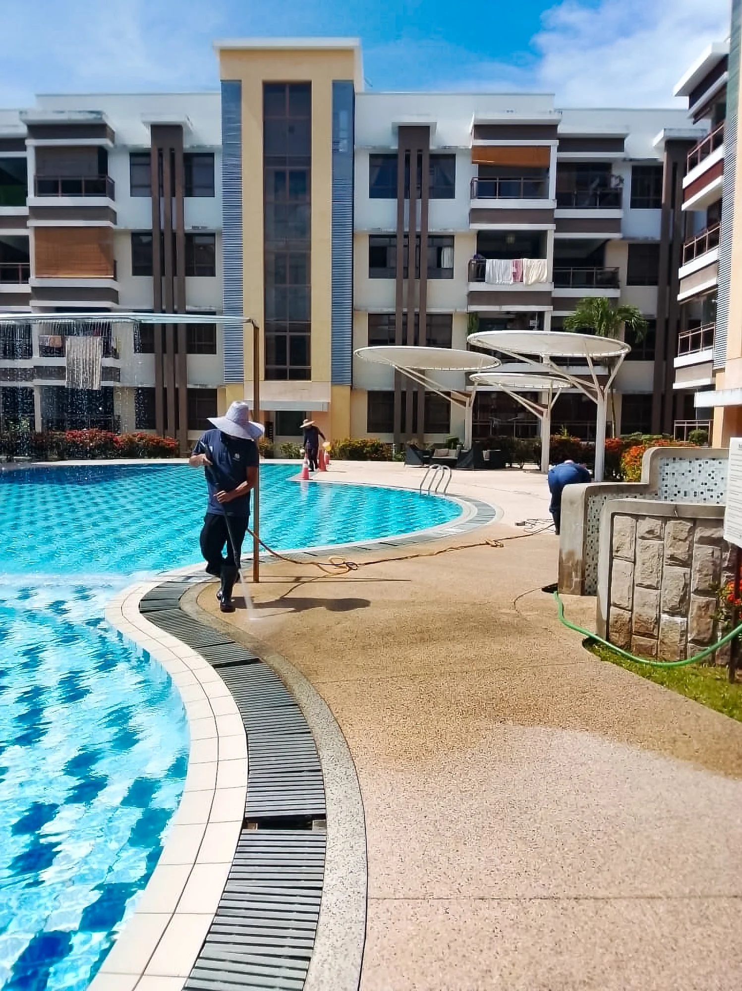Professional cleaning taking place in an apartment complex, with a modern multi-story building in the background.