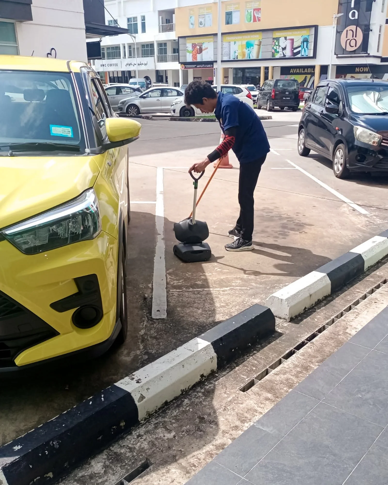 Floor sweeping taking place outside at a commercial complex in Brunei.