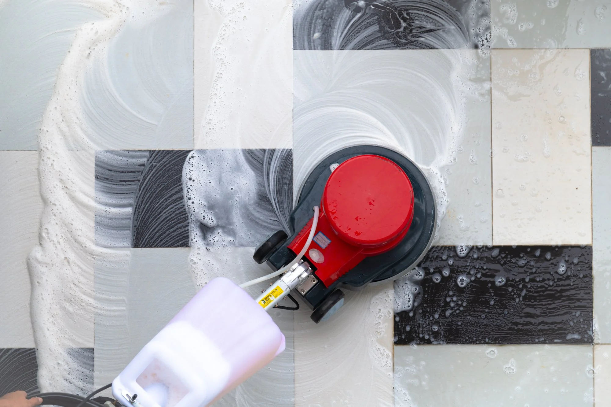 Professional outdoor floor cleaning service using a brushing machine on a residential floor in Brunei.