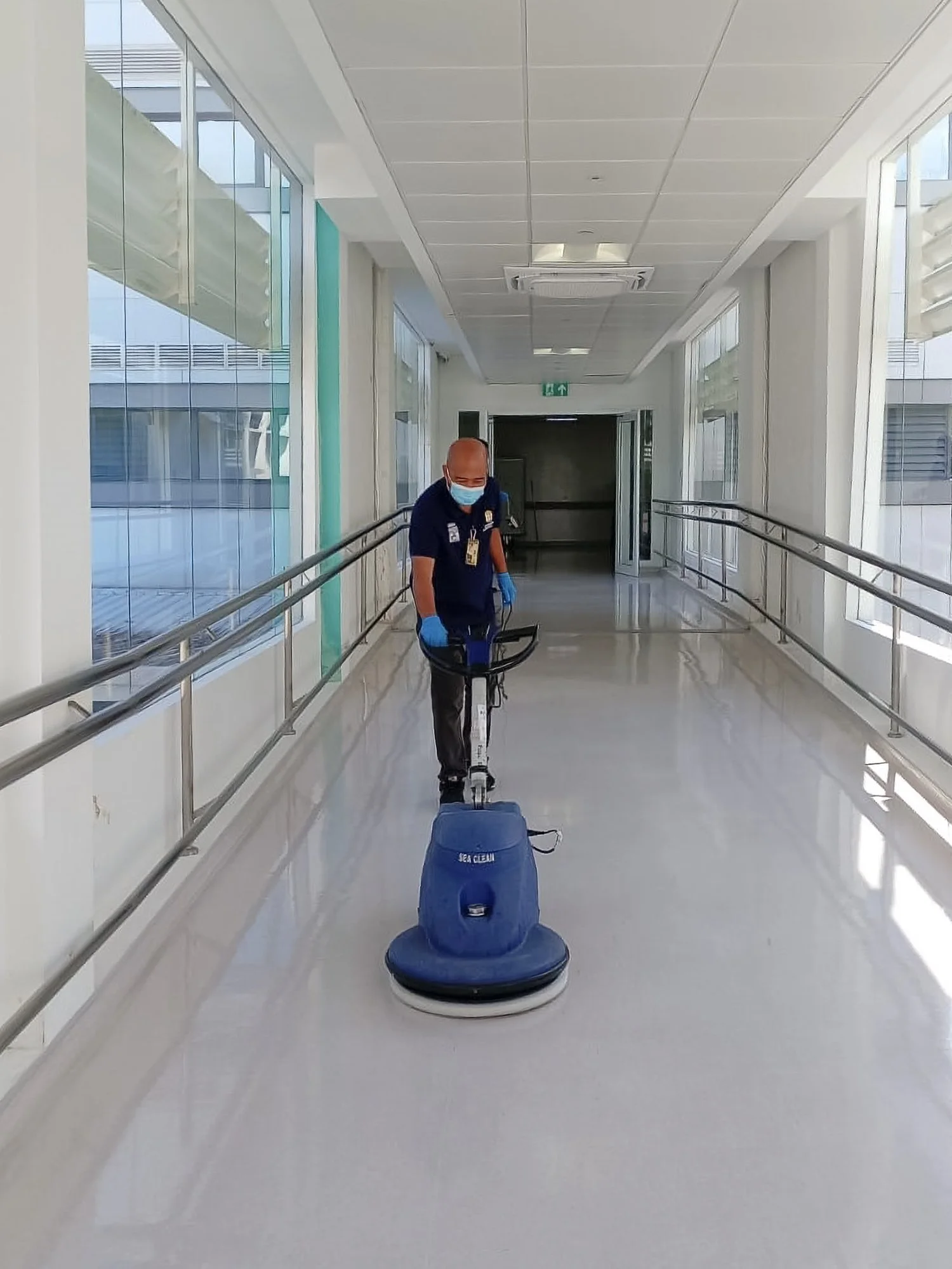 Professional floor polishing taking place in a corridor of a commercial building in Brunei.