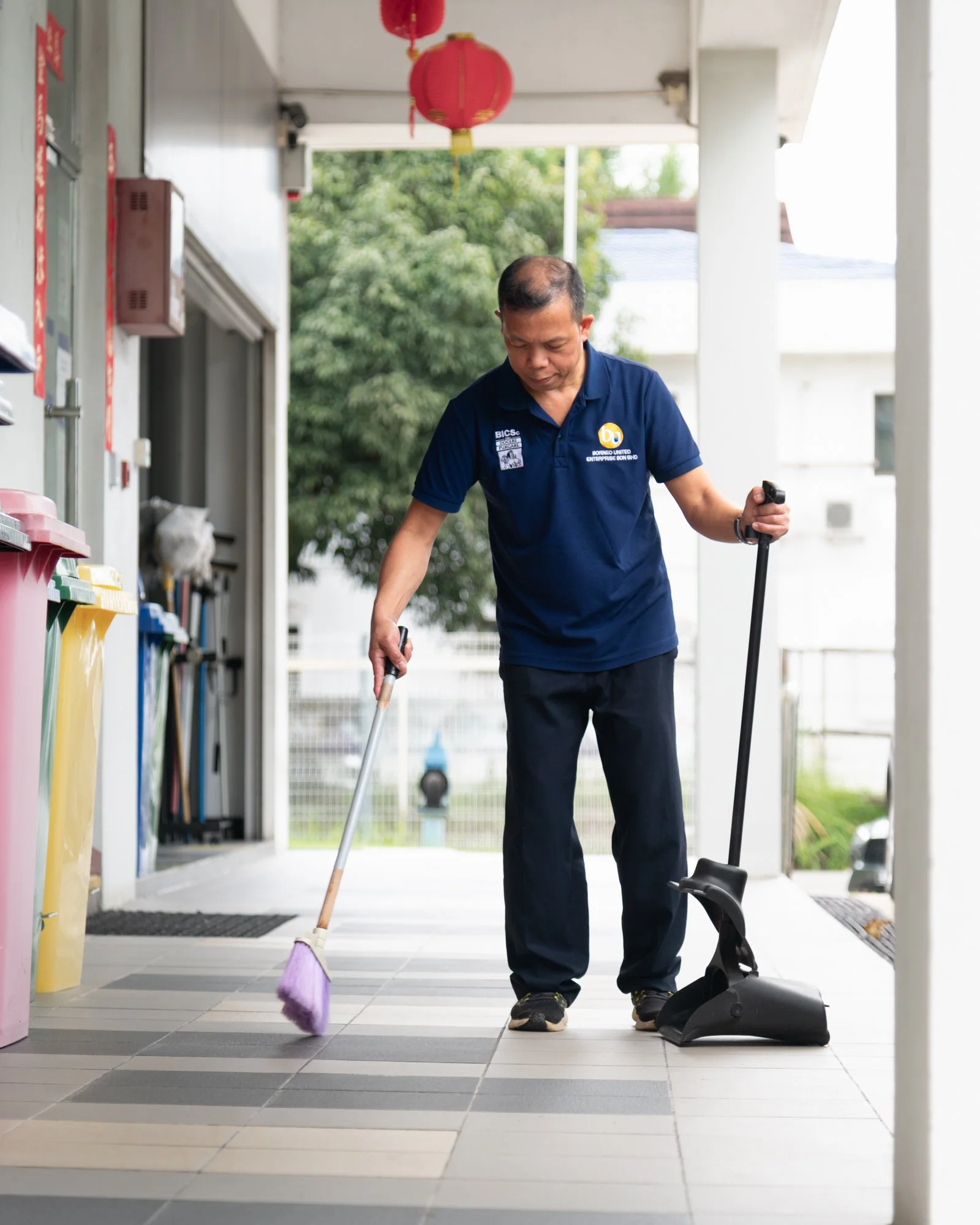 Professional janitorial cleaning and sweeping taking place outside an office in Brunei.