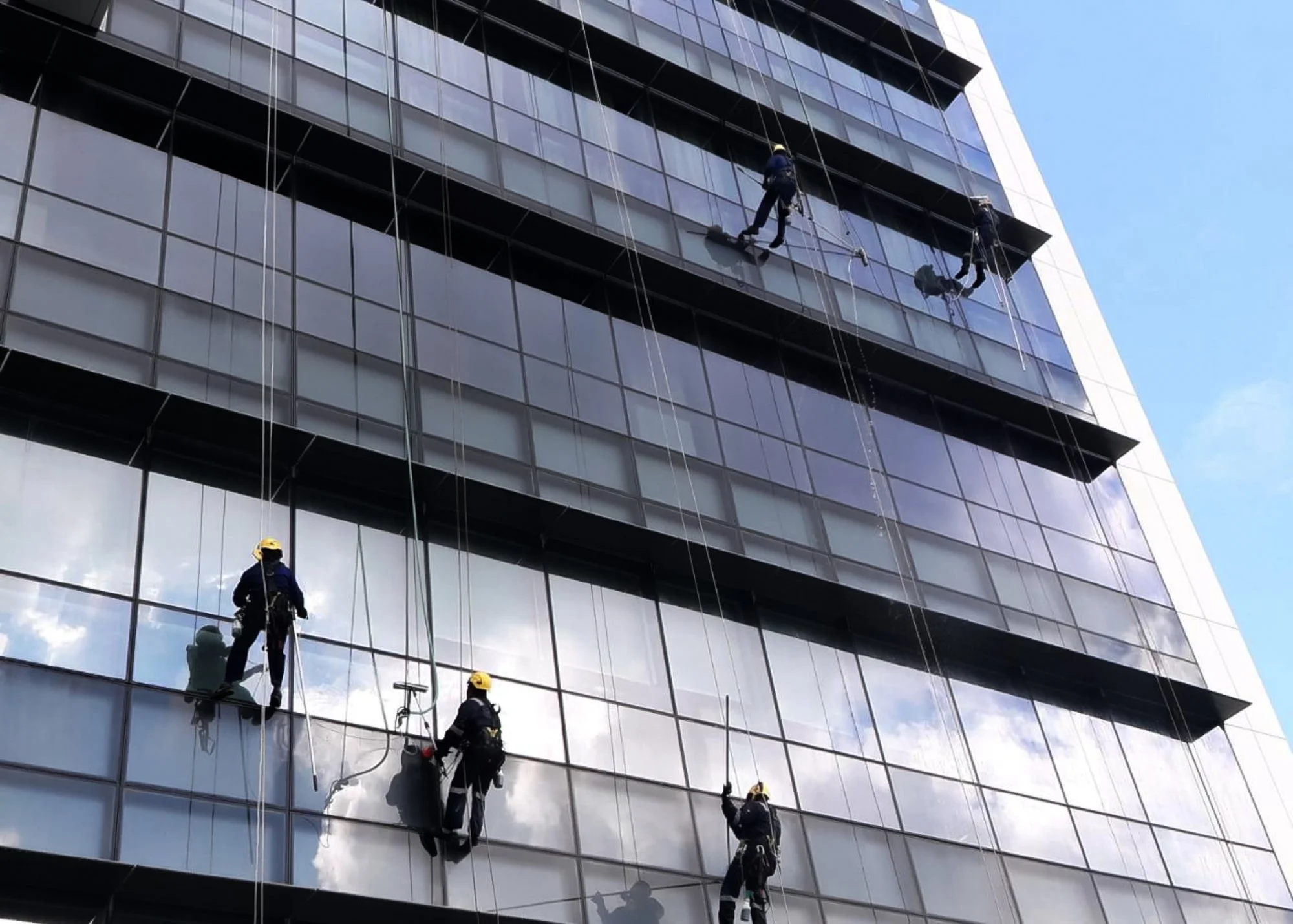 Professional facade and high-rise window cleaning services for a tall glass commercial building in Brunei.