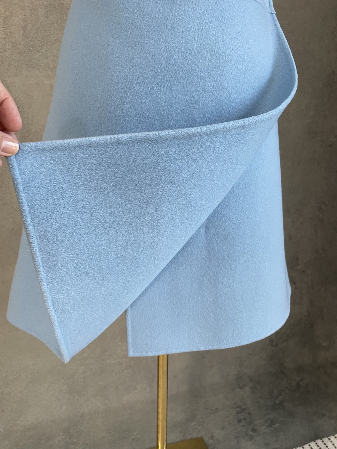 Detail shot showing the folded edge of the cashmere wrap panel and subtle side seam