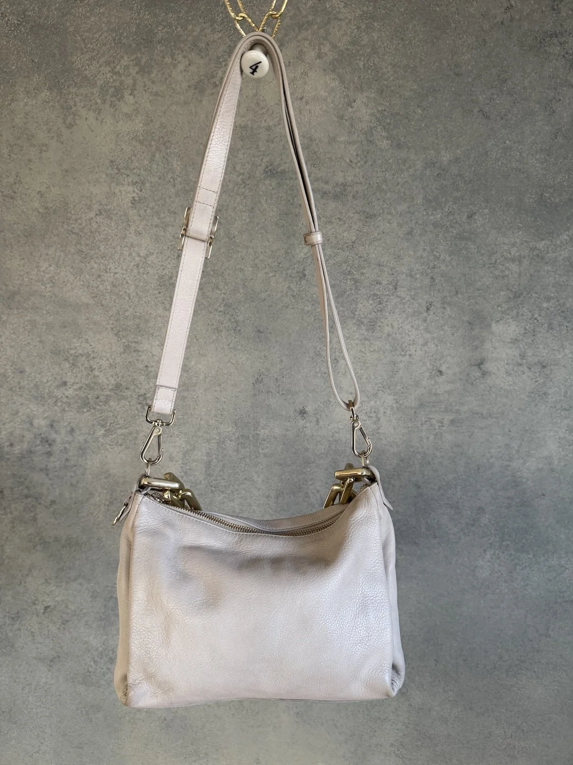 Back view of Adax light greige leather bag showing clean finish and adjustable strap